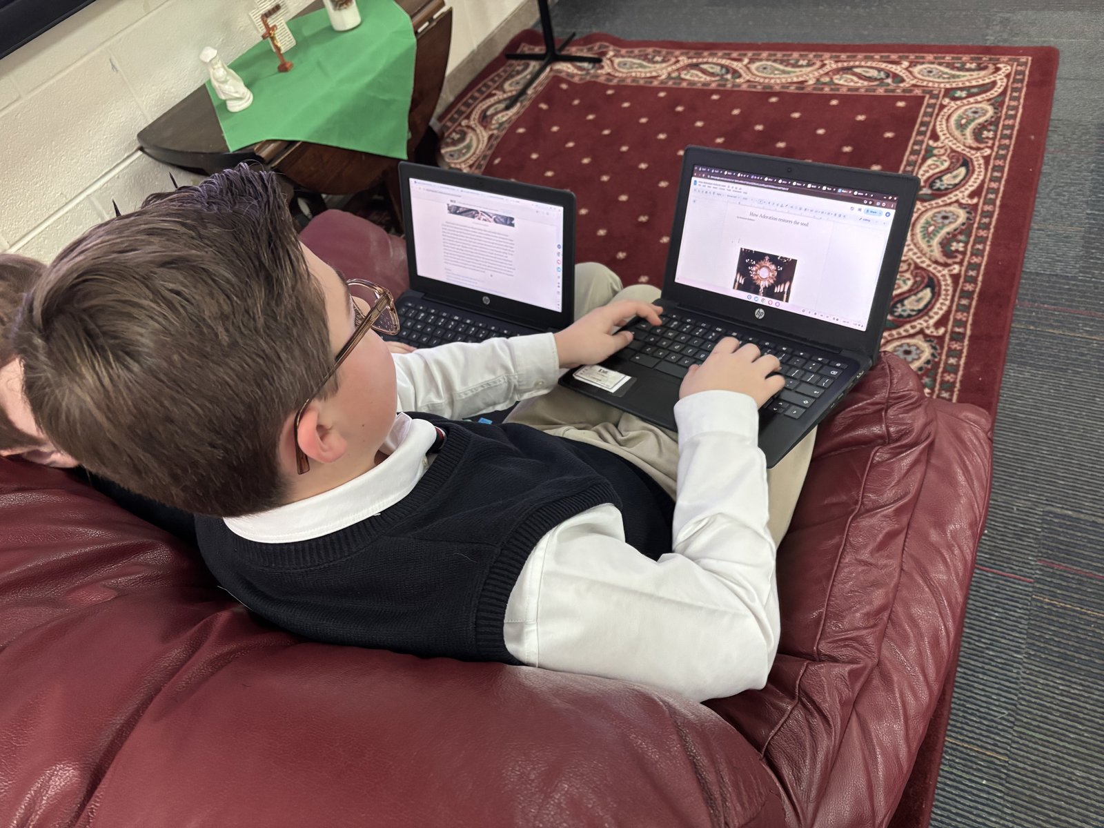 A middle school student at St. Joseph School in Lake Orion reviews an article in Luis Nava's online newspaper, "The Catholic Michigander."