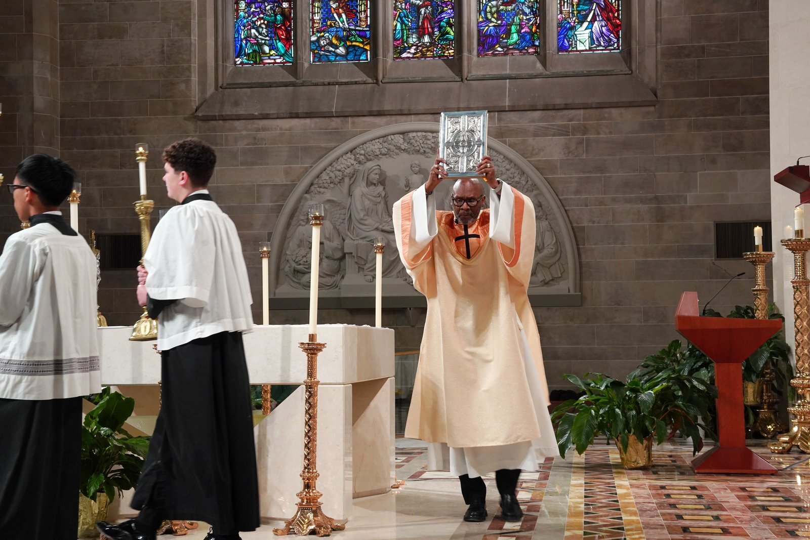 El diácono Michael Heard, de la parroquia Our Lady of Sorrows de Farmington, porta el Libro de los Evangelios durante la Misa por la Justicia y la Paz. (Daniel Meloy | Detroit Catholic)