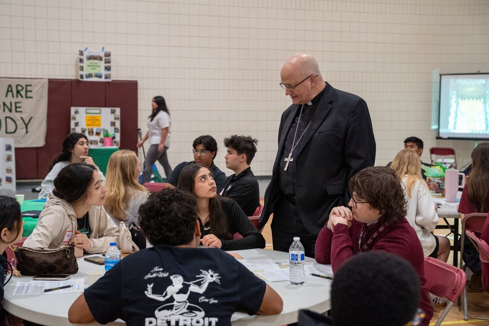El arzobispo de Detroit, Edward J. Weisenburger, conversa con estudiantes de secundaria durante la sexta conferencia anual “Missionaries of Hope” Youth in Action for Immigration, organizada por Strangers No Longer, en el Johnson Recreation Center de la University of Detroit Jesuit. El arzobispo destacó y valoró la presencia de tantos jóvenes en el encuentro, subrayando su compromiso con un trato justo hacia los inmigrantes.