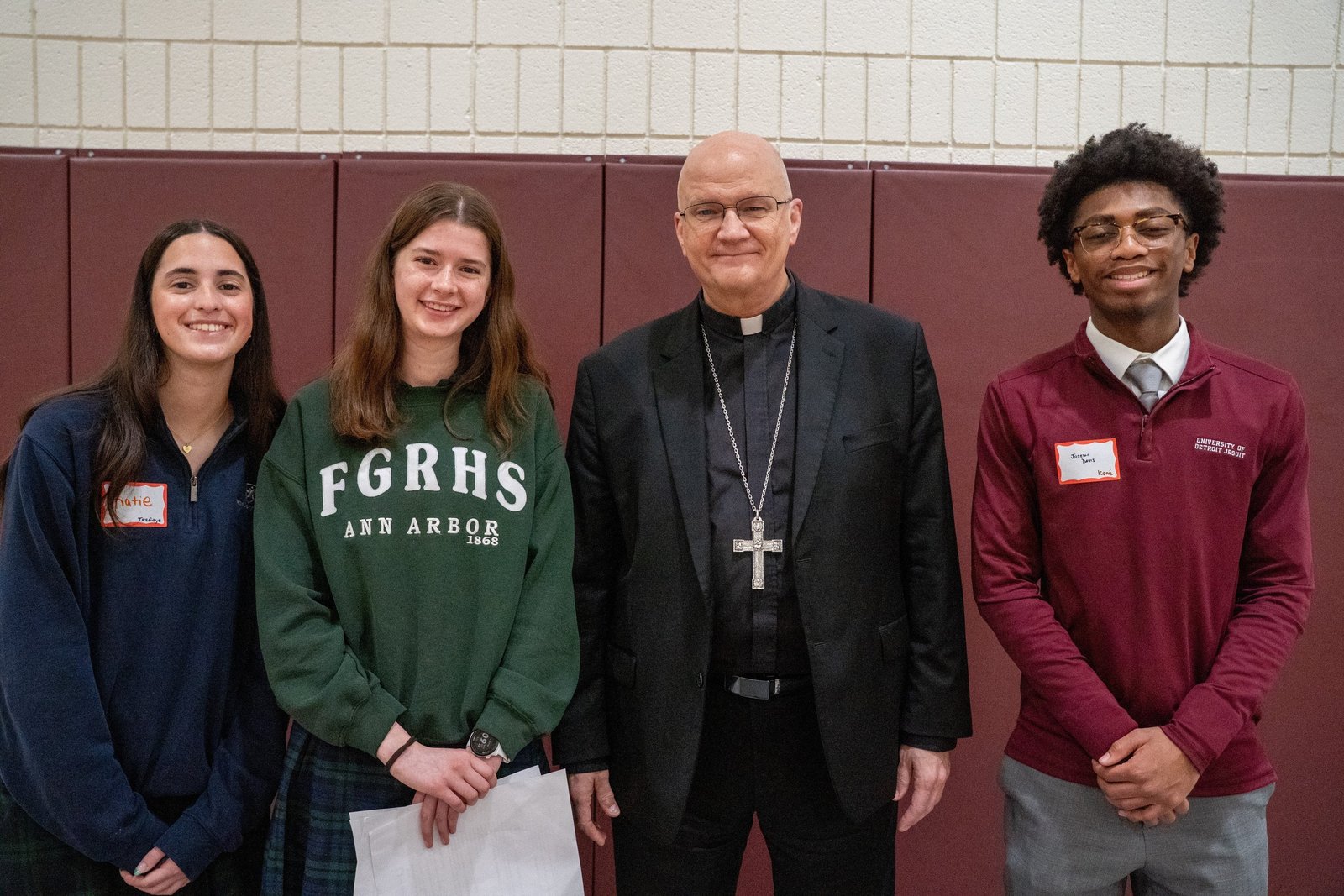 El arzobispo Weisenburger posa junto a los tres coorganizadores de la conferencia: Katie Fortino, de Notre Dame Preparatory en Pontiac; Sofia Dussan, de Fr. Gabriel Richard High School en Ann Arbor; y Joseph Davis, de University of Detroit Jesuit High School.