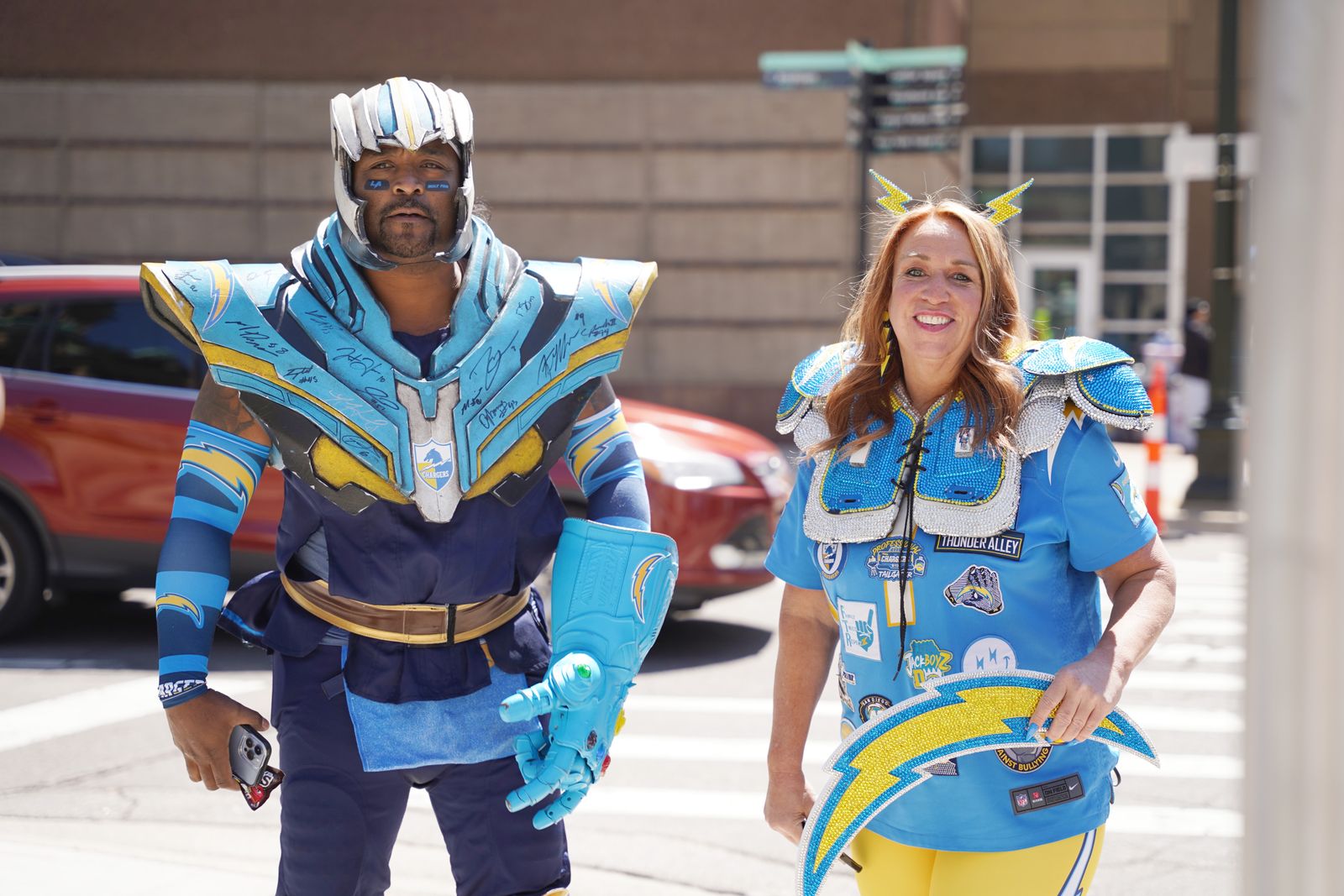 Una pareja de aficionados de los Los Angeles Chargers pasa junto a la NFL Fan Zone cerca del Campus Martius Park en el centro de Detroit antes del inicio del Draft de la NFL. Miles de aficionados del futbol han llegado al centro de Detroit para el Draft de la NFL, del 25 al 27 de abril, un lugar perfecto para la evangelización pública.