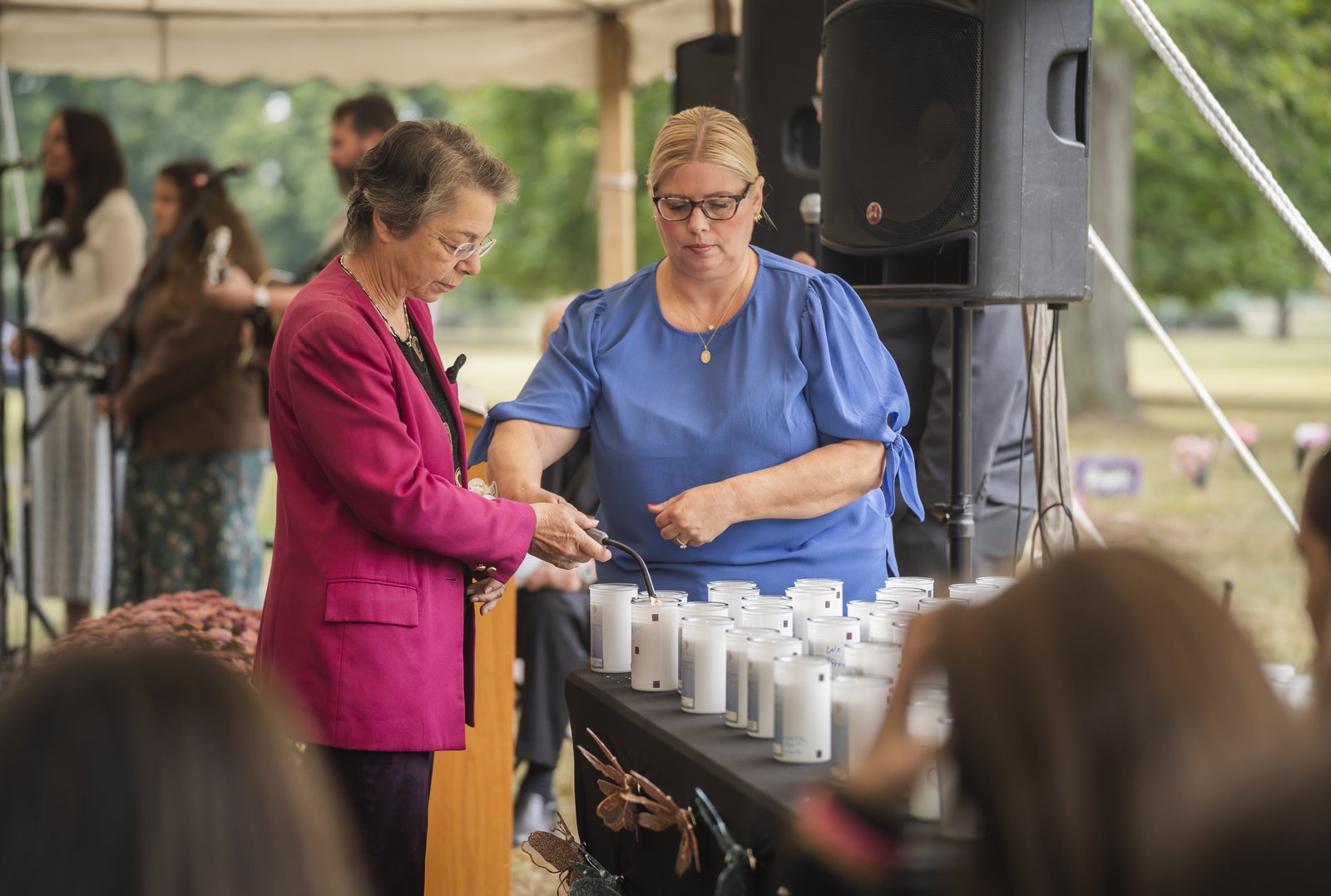 Local pro-life leader Monica Miller, left, and Deanna Cortese, outreach director for Catholic Funeral and Cemetery Services in the Archdiocese of Detroit, light candles during the memorial dedication service.