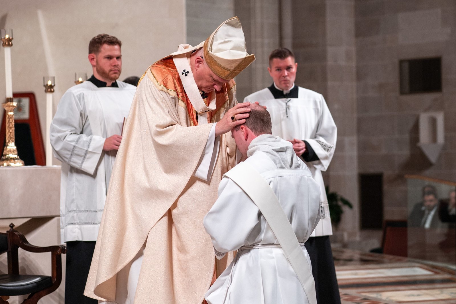 Archbishop Edward J. Weisenburger lays his hands upon the head of Fr. Daniel Whalen to ordain him to the priesthood.