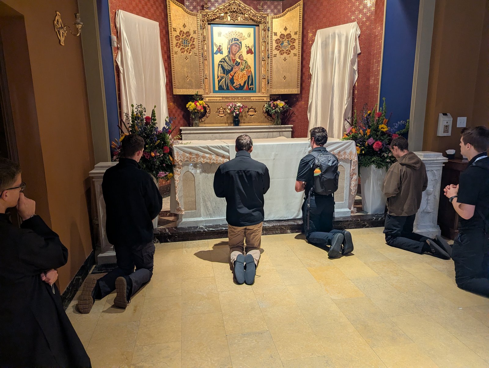 Seminarians from Sacred Heart Major Seminary in Detroit pray at Archbishop Sheen's tomb in a side chapel of the Cathedral of St. Mary of the Immaculate Conception in Peoria, Ill., on Sept. 23, on their way to St. Louis for the beatification Mass.