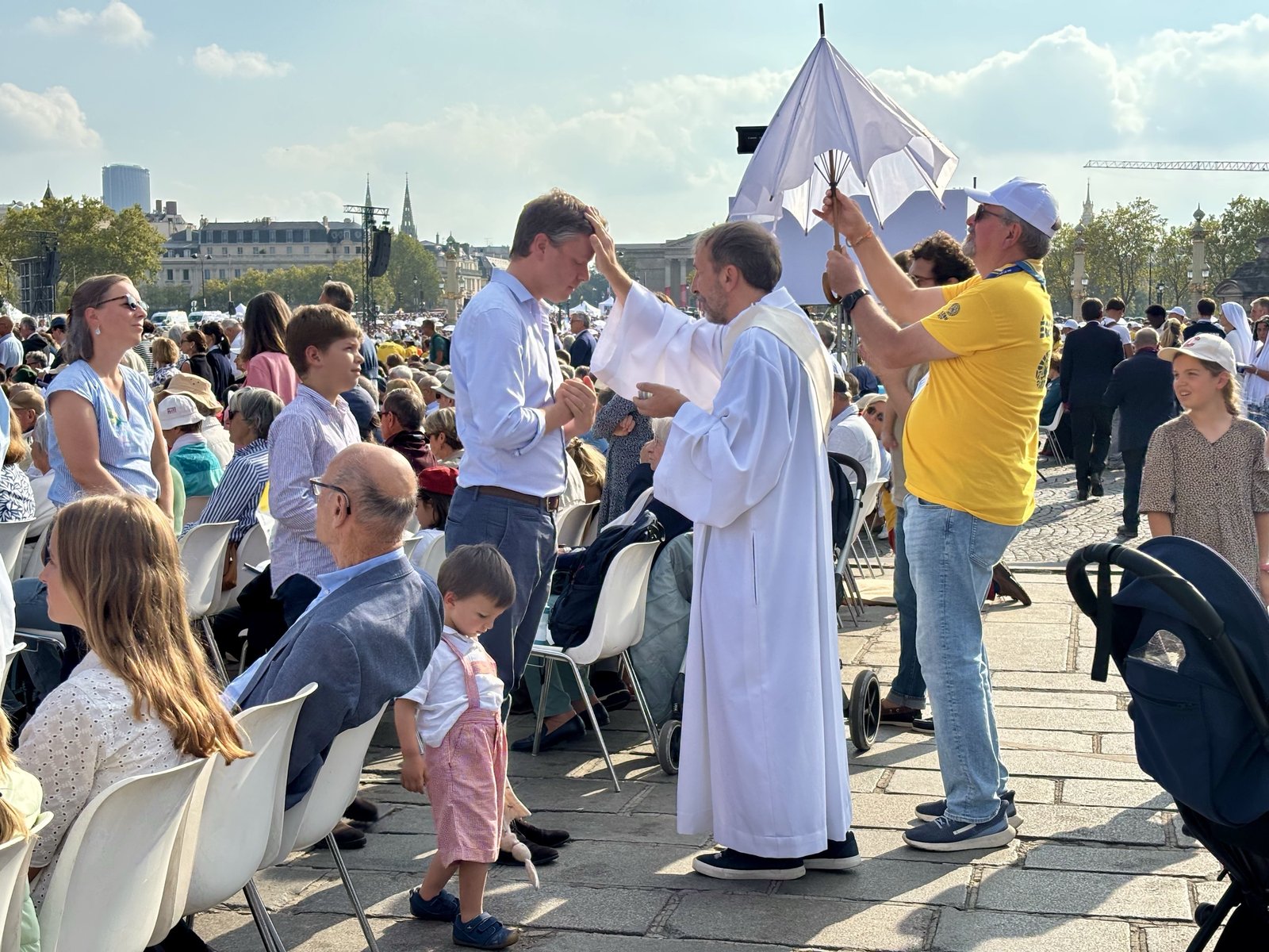 Un peregrino recibe una bendición durante una Misa al aire libre en el viaje apostólico del Papa León XIV a Francia. | Crédito: Solène Tadié.