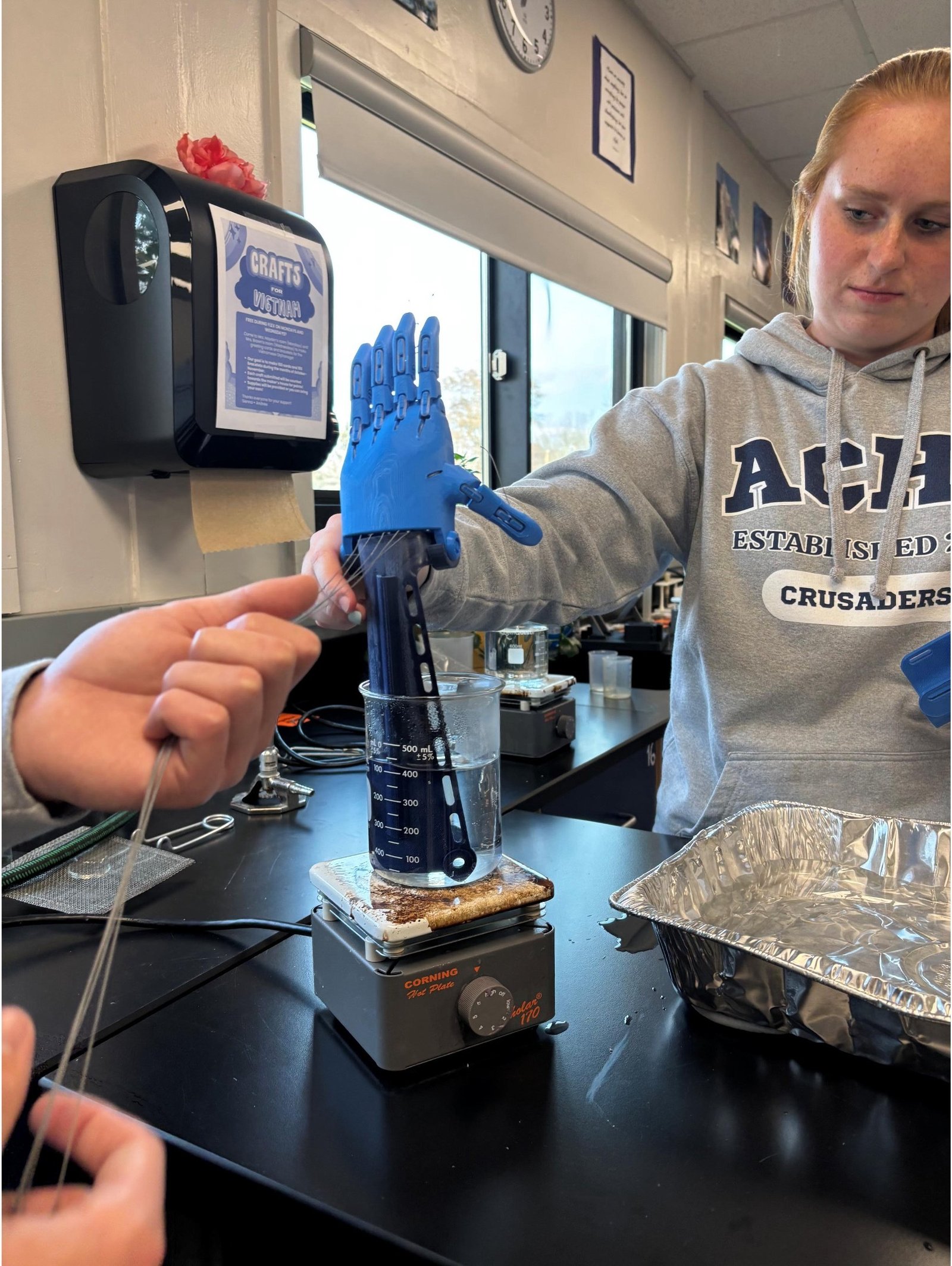 Abigail Glynn and a partner work on the prosthetic hand they will gift to third-grader Kaysen Green of Grand Haven. The hand is the first project the Austin Catholic STEAM program has completed as part of the e-NABLE program.