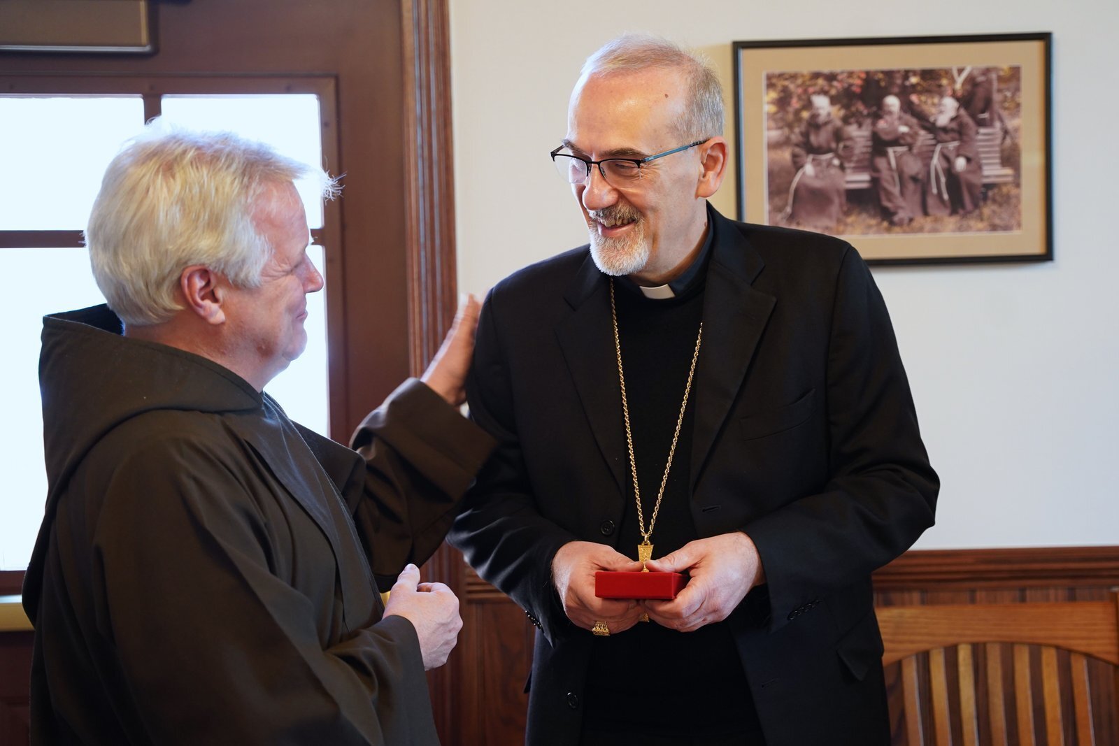 El padre Mark Joseph Costello, OFM Cap., a la izquierda, ministro provincial de la Provincia San José de los Franciscanos Capuchinos, entrega al cardenal Pierbattista Pizzaballa, OFM, patriarca latino de Jerusalén, una reliquia de primera clase del beato Solanus Casey durante la visita del cardenal al Centro Solanus Casey, el 5 de diciembre. (Foto de Daniel Meloy | Detroit Catholic)