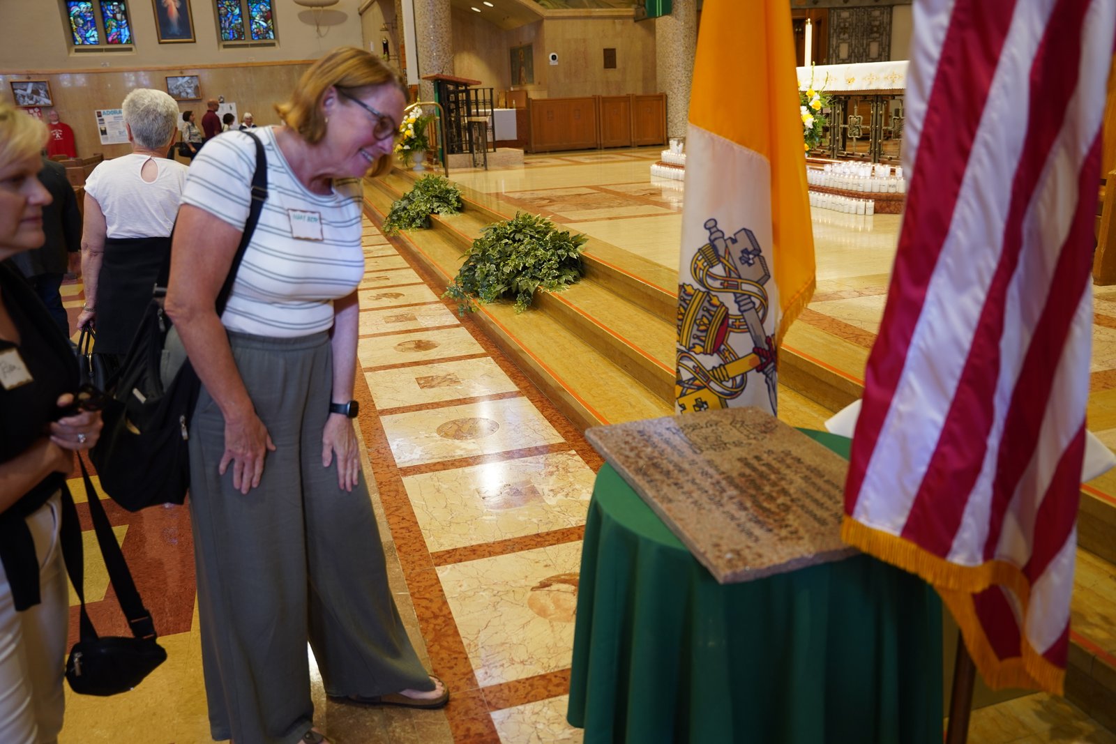 Feligreses observan la placa conmemorativa de la ordenación diaconal del papa León XIV después de la misa. Las liturgias del 12 y 13 de septiembre conmemoraron el aniversario de la ordenación del papa, la cual tuvo lugar en Santa Clara de Montefalco el 10 de septiembre de 1981.