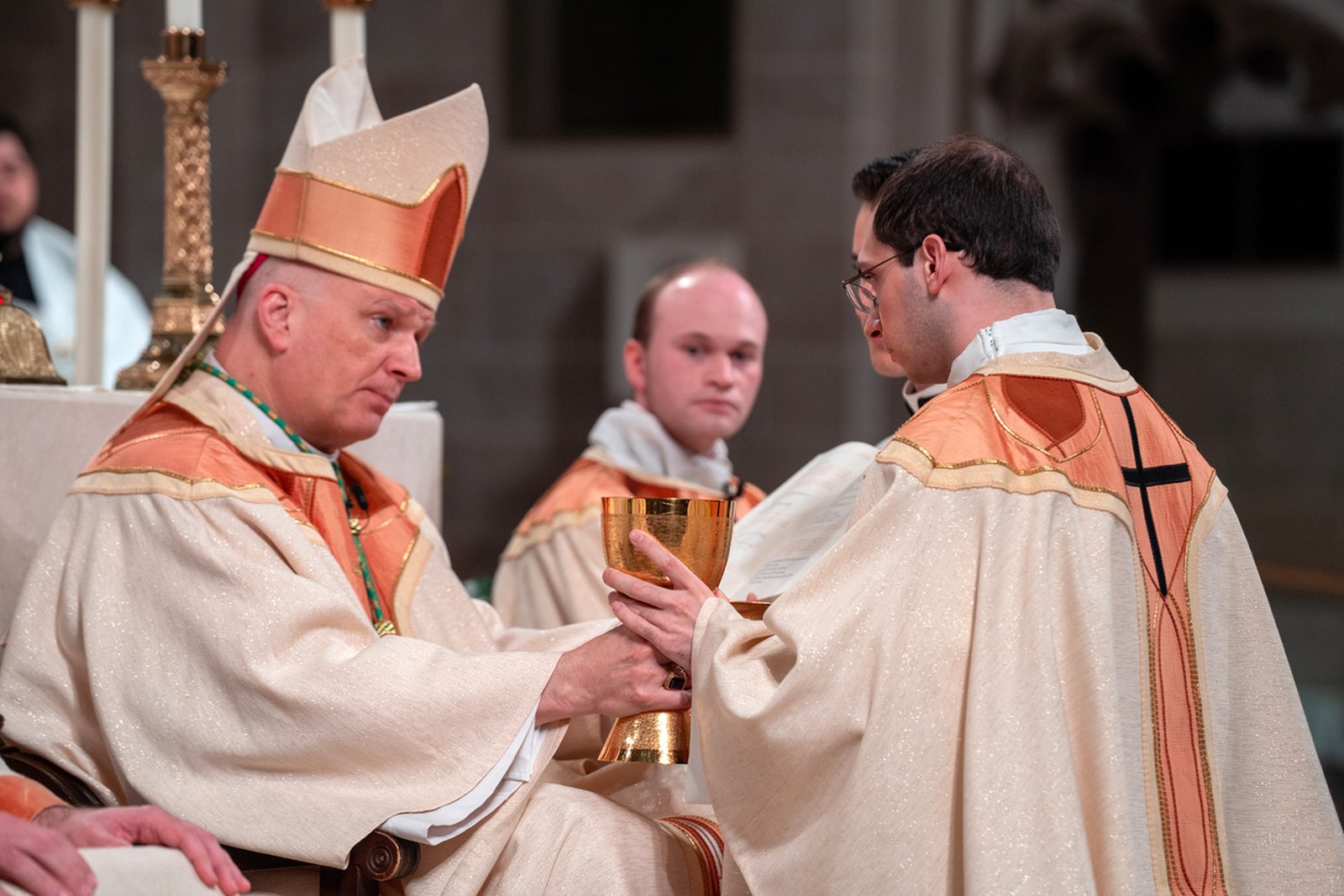 Archbishop Weisenburger entrusts the chalice to Fr. Schroder, part of the rite of ordination.