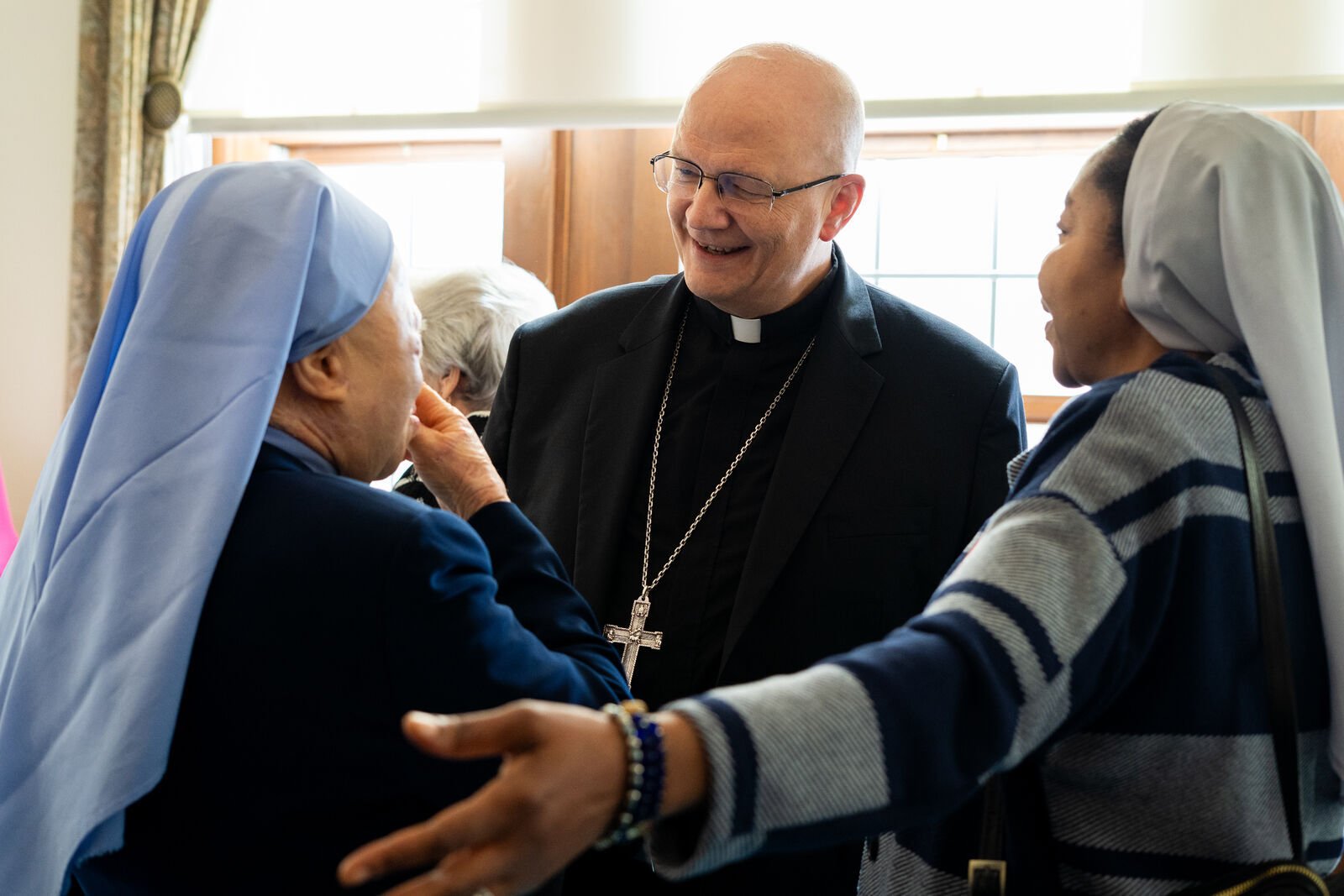 Archbishop Weisenburger greets women religious at a lunch following Mass at Sacred Heart Major Seminary.