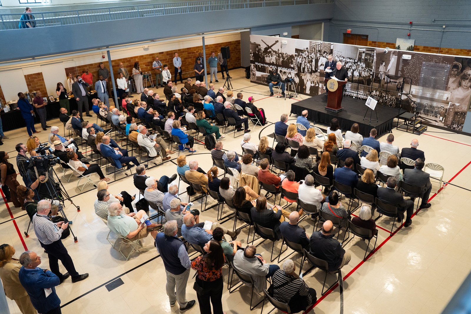 Guests fill the former gymnasium of St. Matthew school for the press conference introducing the new Residences at St. Matthew on May 7.