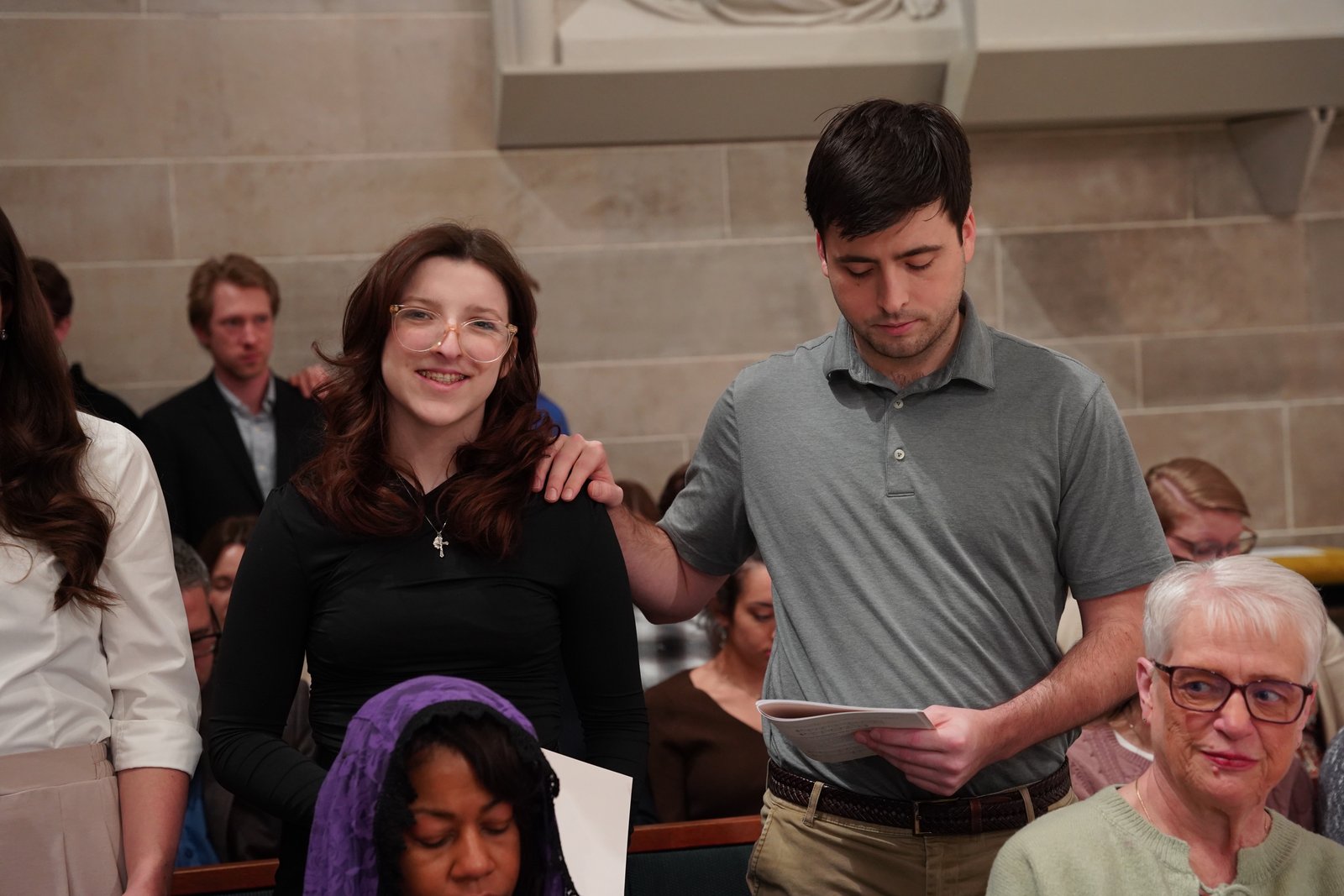 Anthony Roux places his hand on his sister, Amar Roux, a senior at Milford High School who will be confirmed this Easter at St. Mary of the Snows Parish in Milford. Roux is part of growing trend of young people showing an interest in religion, particularly Catholicism.