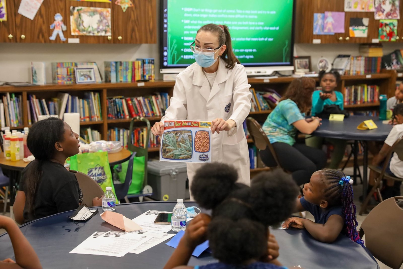 "Rocket Rachel", una profesora de Mad Science: Detroit, explica a los campistas qué es la goma guar durante una sesión de aprendizaje STEM (ciencia, tecnología, ingeniería y matemáticas) sobre cómo hacer slime durante el campamento de verano por la paz Rosa Parks, el 28 de julio en el Capuchin Soup Kitchen.