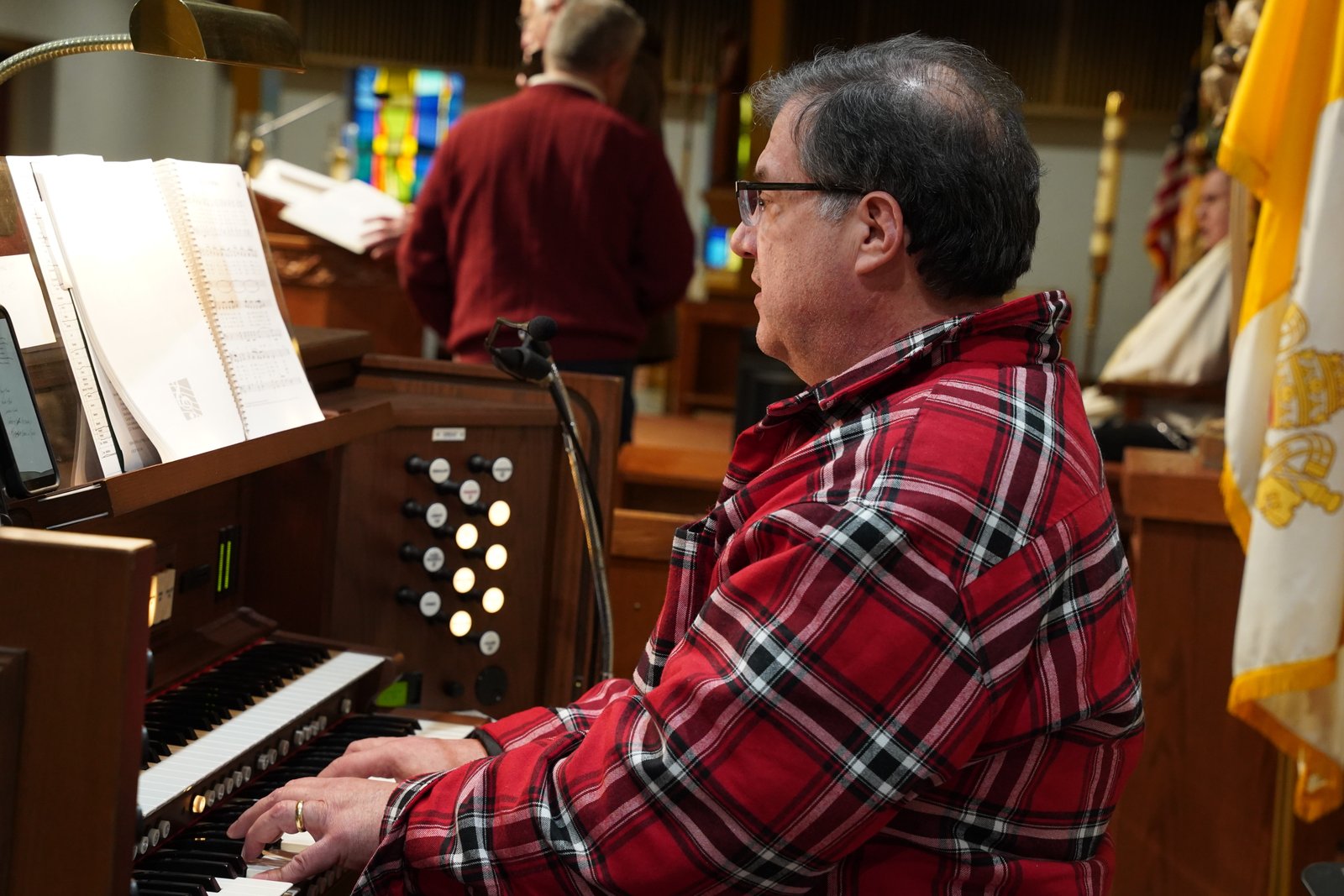 Kevin Jakubowicz, organist at St. Kateri Parish, gives parents and children a preview of the hymns they will hear this Christmas.