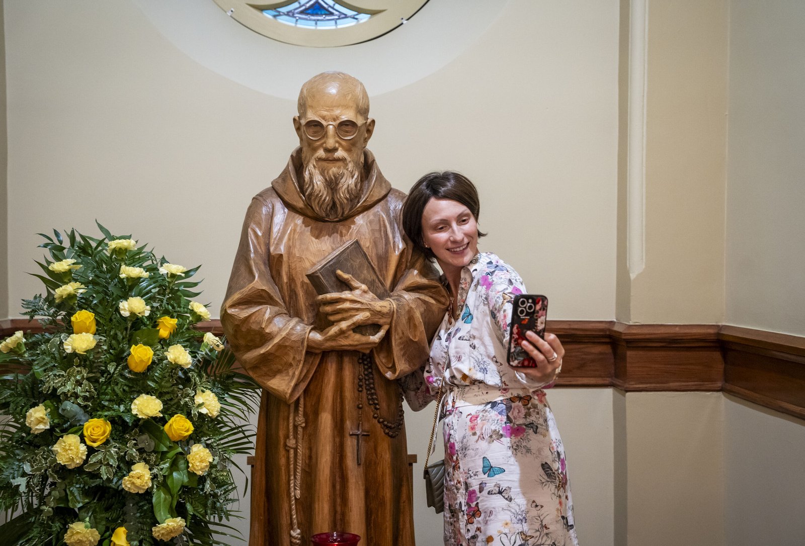 A woman takes a selfie with a statue of Blessed Solanus Casey. In his homily, Archbishop Weisenburger attributed the fast-moving cause of Blessed Solanus to the devotion of the people.