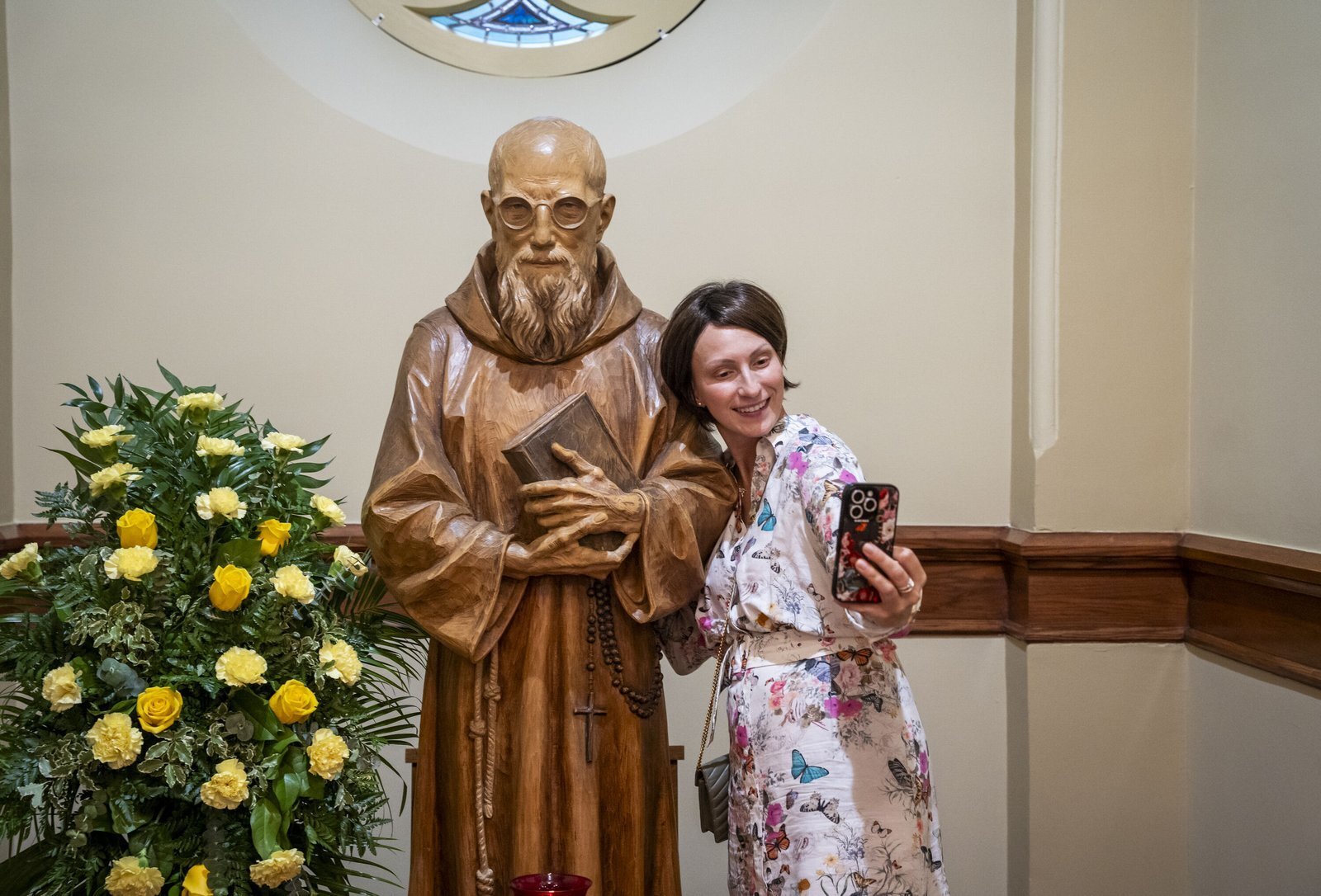 Una mujer se toma una selfie junto a una estatua del beato Solano Casey. En su homilía, el Arzobispo Weisenburger atribuyó el rápido avance de la causa del beato Solano a la devoción del pueblo.