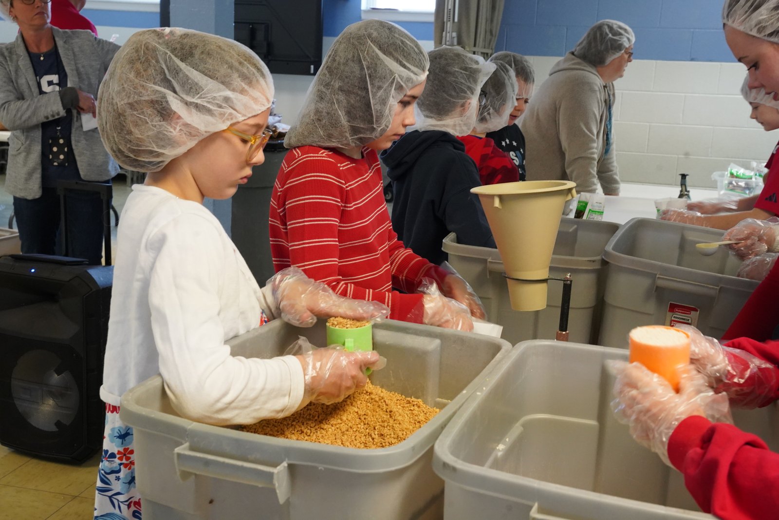 Students wore gloves and hairnets as they placed portions of rice, soy, vegetables and chicken-flavored vitamins in sealed packages.