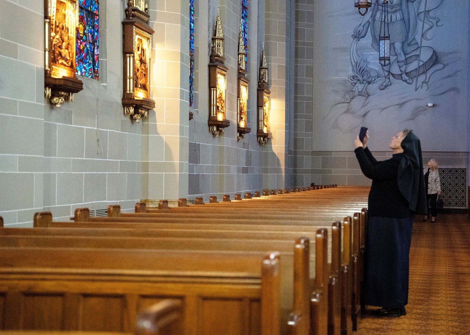 Sr. Esther Mary Nickel, RSM, director of sacred worship for the Archdiocese of Detroit, snaps a photo of the Stations of the Cross inside St. Florian Church in Hamtramck.