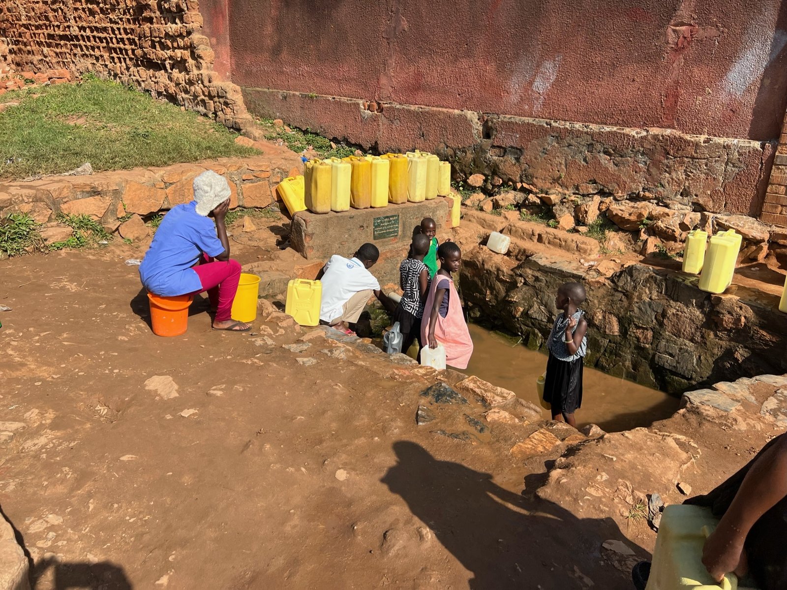 Neighborhood children collect water for their homes in Kampala, Uganda.