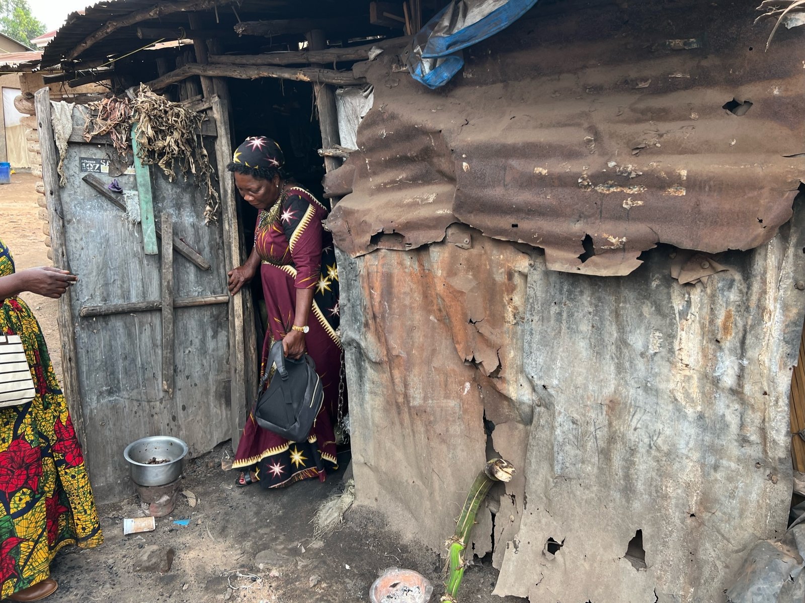 A resident exits her home in the neighboring St. Kizito slums.
