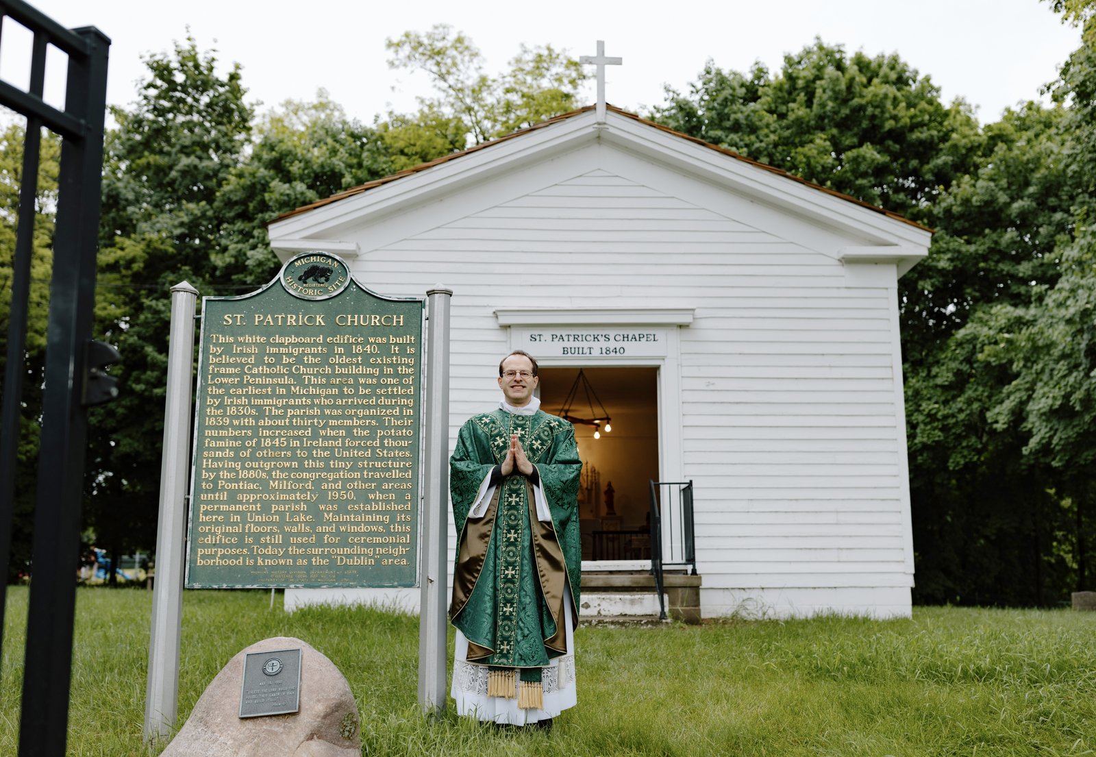 El Padre David Cybulski, moderador y párroco solidario en la St. Patrick Parish, está parado afuera de la histórica capilla de 1840 después de la misa. Durante generaciones, los sacerdotes en St. Patrick han cuidado este humilde sitio histórico, la estructura católica más antigua en la península inferior de Michigan.