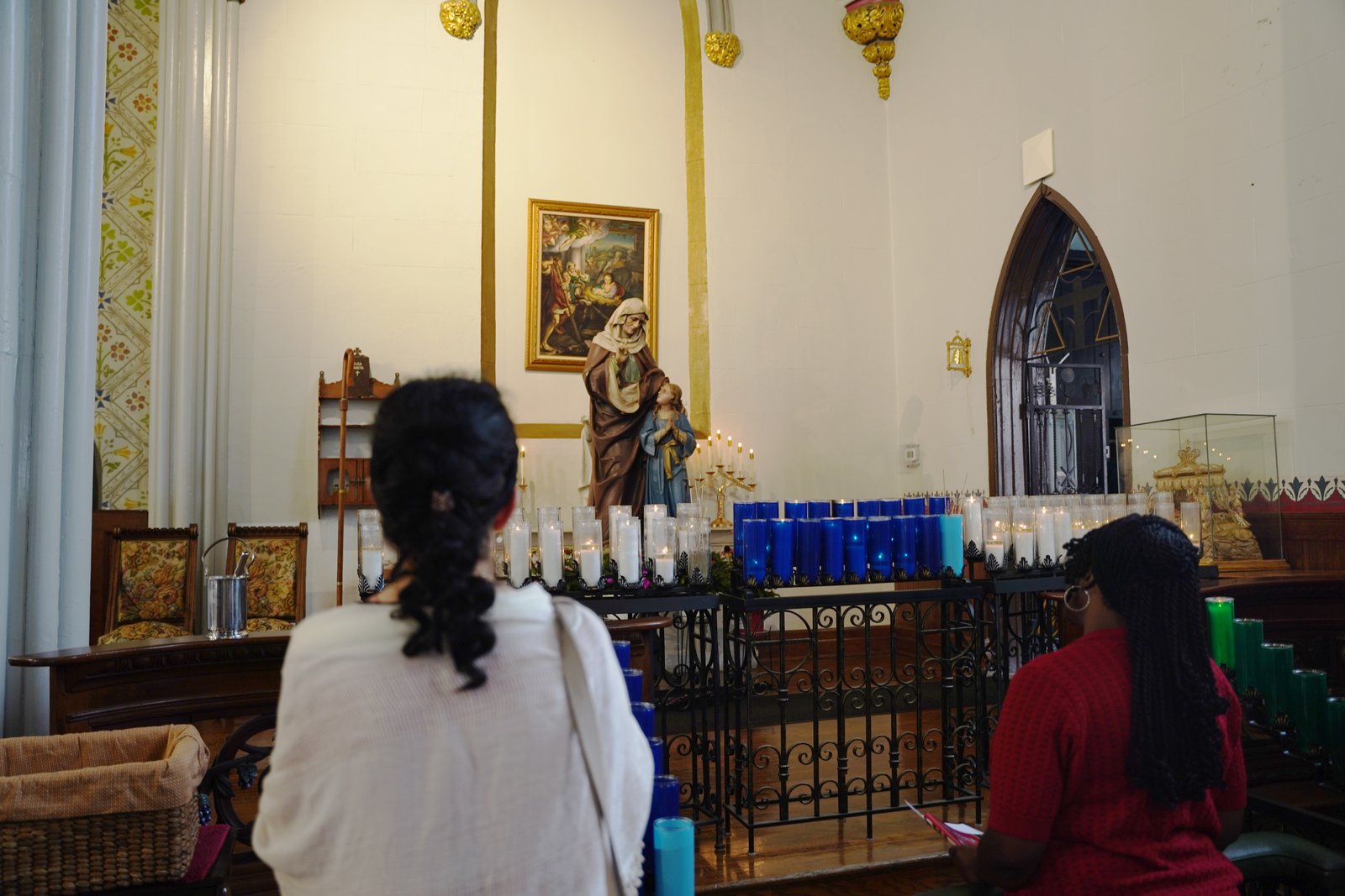 Varias personas se detienen a rezar ante una estatua de Santa Ana y la Virgen María después de la Misa en la Parroquia Most Holy Trinity en Detroit. La devoción católica tradicional a Santa Ana consiste en pedir un cónyuge o rezar para que los hijos encuentren esposos buenos y santos.