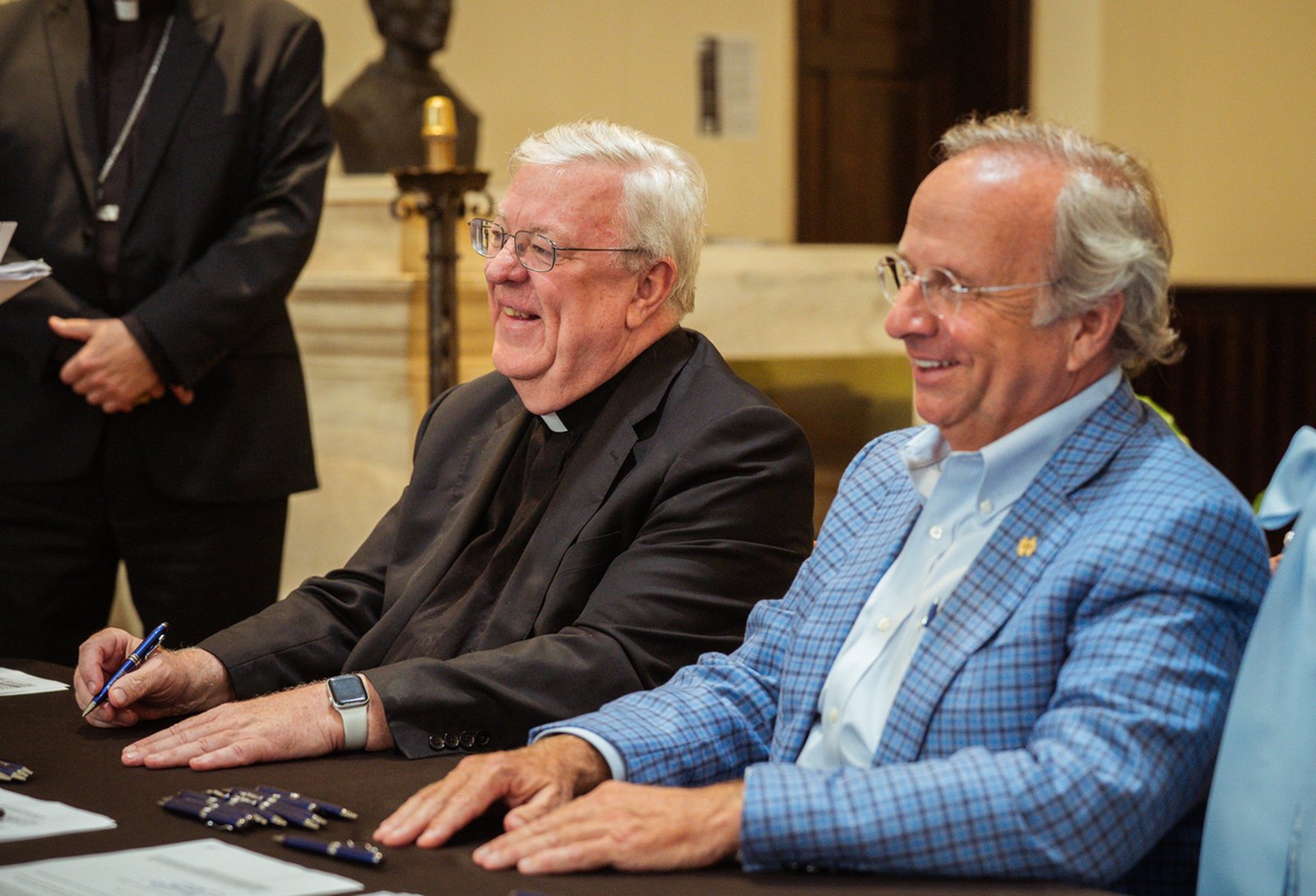 Msgr. Charles Kosanke, rector of the Basilica of Ste. Anne, and Mark Pulte, chairman of the board of directors of The Catholic Initiative, smile during a signing ceremony July 16 in the basilica's chapel.