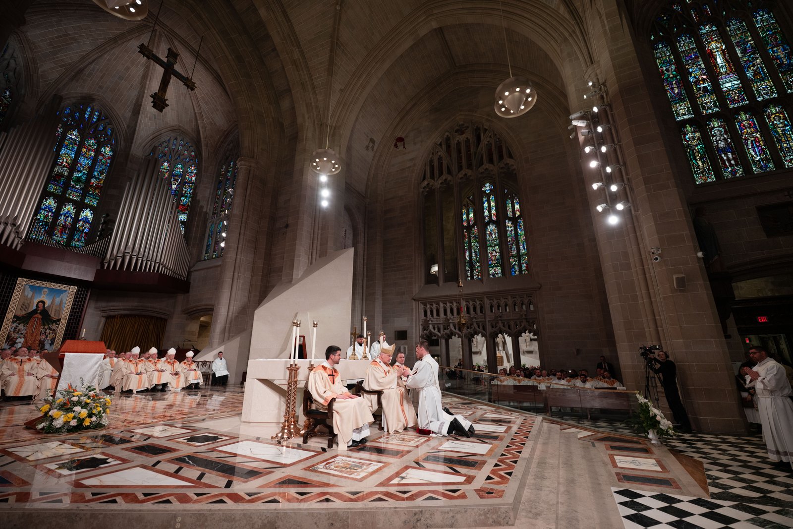 Archbishop Weisenburger clasps the hands of each ordinand during the ordination rite as he prays over them.