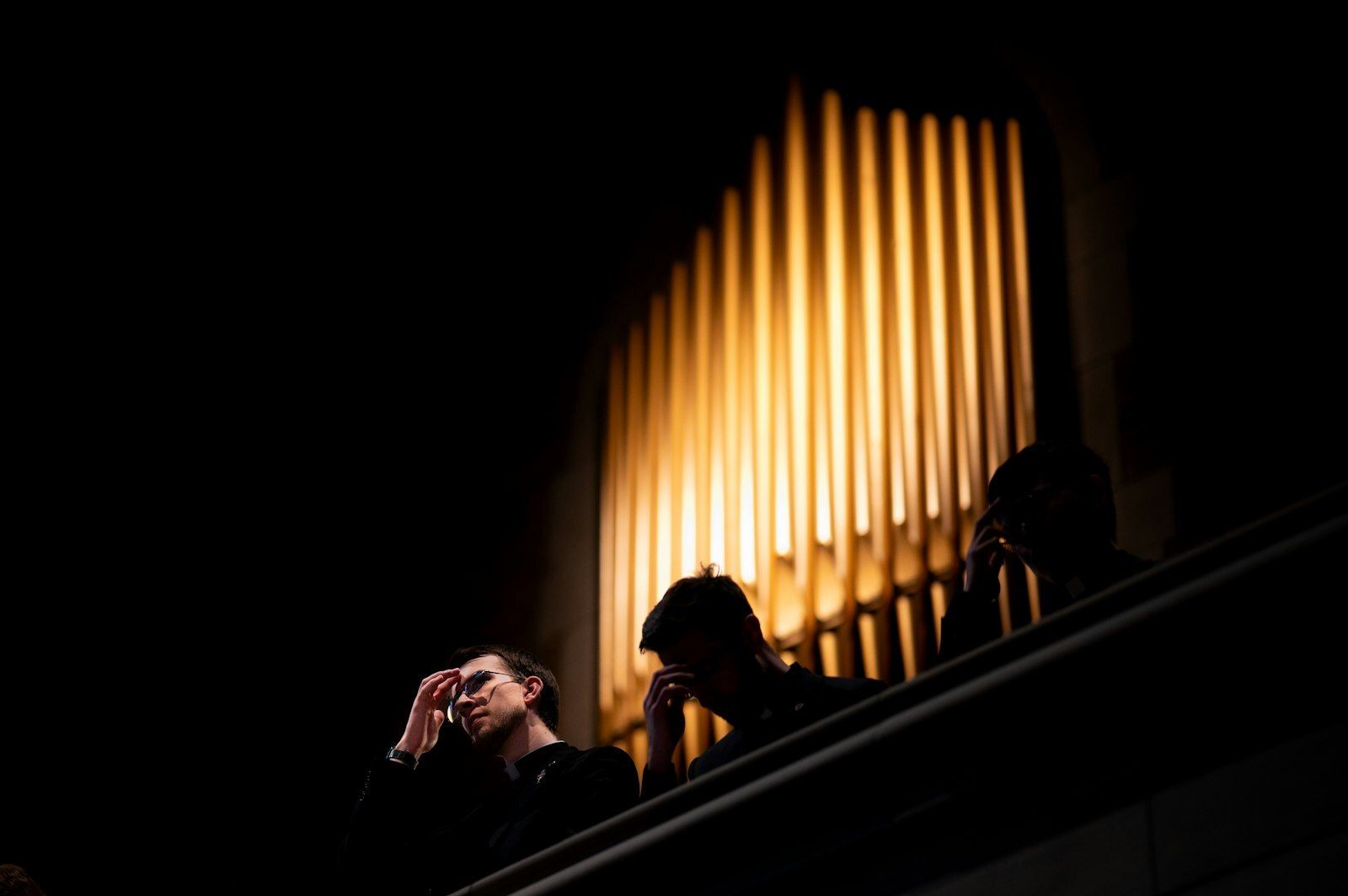 Las personas sentadas en el coro se persignan durante las vísperas solemnes del 17 de marzo en la capilla del Sacred Heart. (Tim Fuller | Especial para Detroit Catholic)