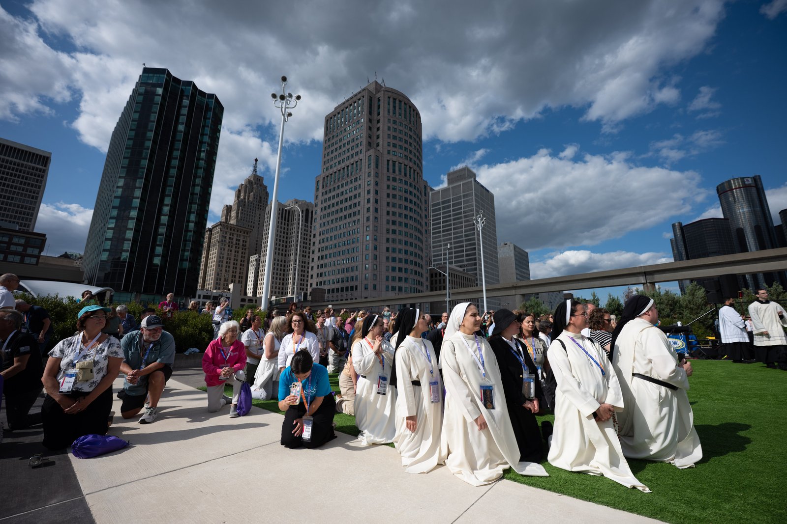Religious and laity kneel in adoration during a Eucharistic procession to the Spirit of Detroit. (Tim Fuller | Detroit Catholic)
