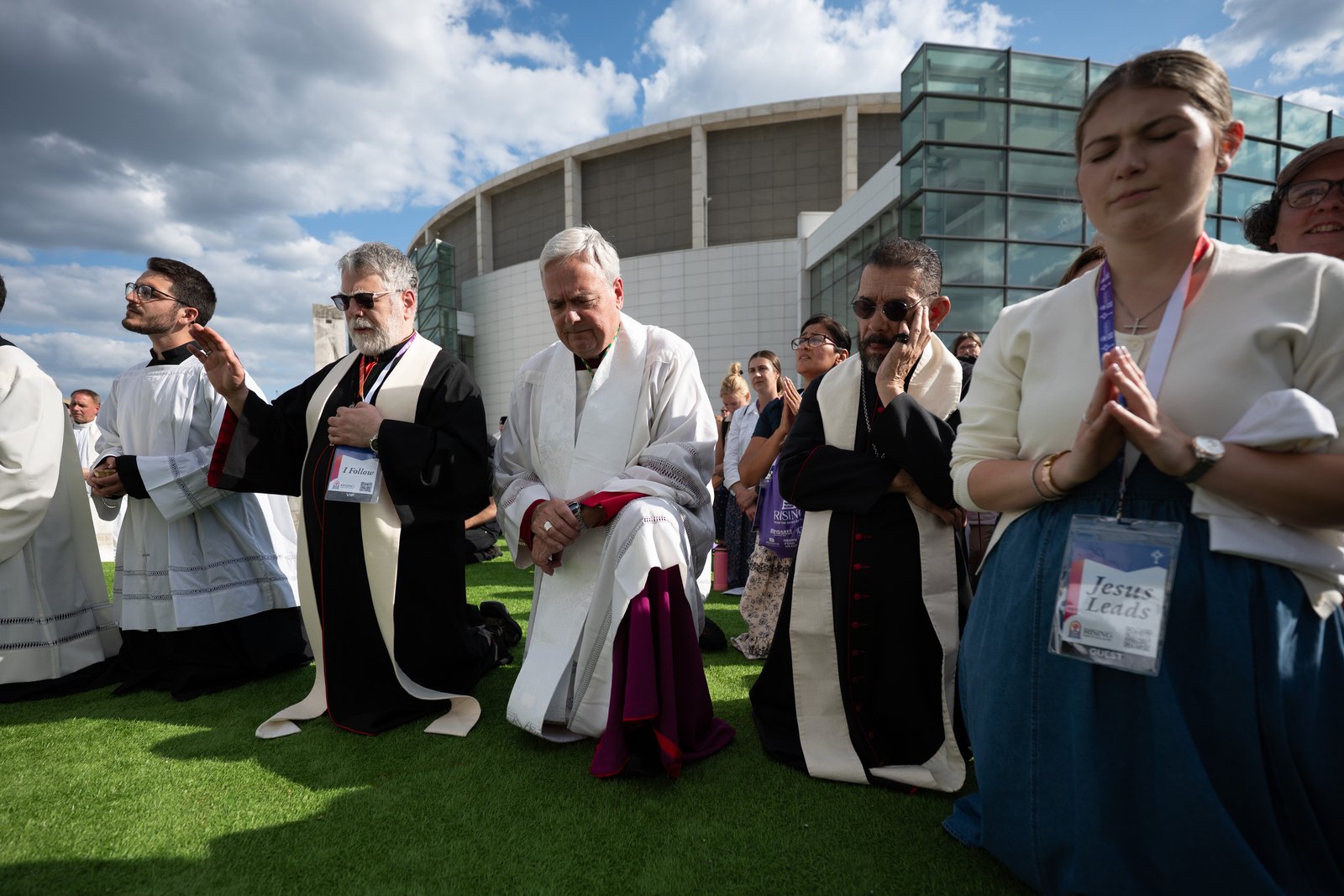 Left to right, Chaldean Bishop Francis Y. Kalabat, Detroit Auxiliary Bishop Robert J. Fisher and Brownsville, Texas, Bishop Daniel E. Flores kneel in adoration outside Huntington Place. (Tim Fuller | Detroit Catholic)