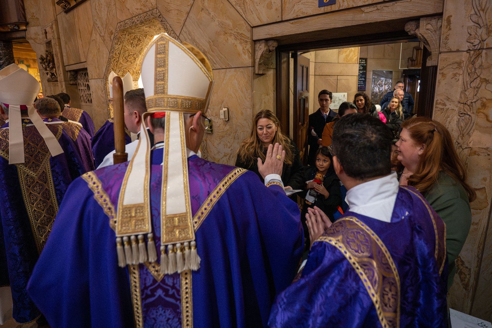 Cardinal Pizzaballa blesses families after Mass at the National Shrine of the Little Flower Basilica. Many parishioners brought rosaries, personal items and holy cards for the patriarch to bless.