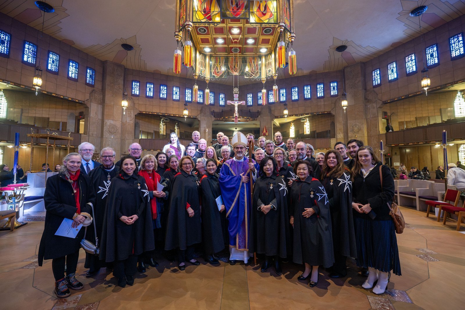 Miembros de los Caballeros y Damas de la Orden de Malta se reúnen para una foto grupal con el cardenal Pierbattista Pizzaballa, OFM, patriarca latino de Jerusalén, en el National Shrine of the Little Flower Basilica, en Royal Oak.
