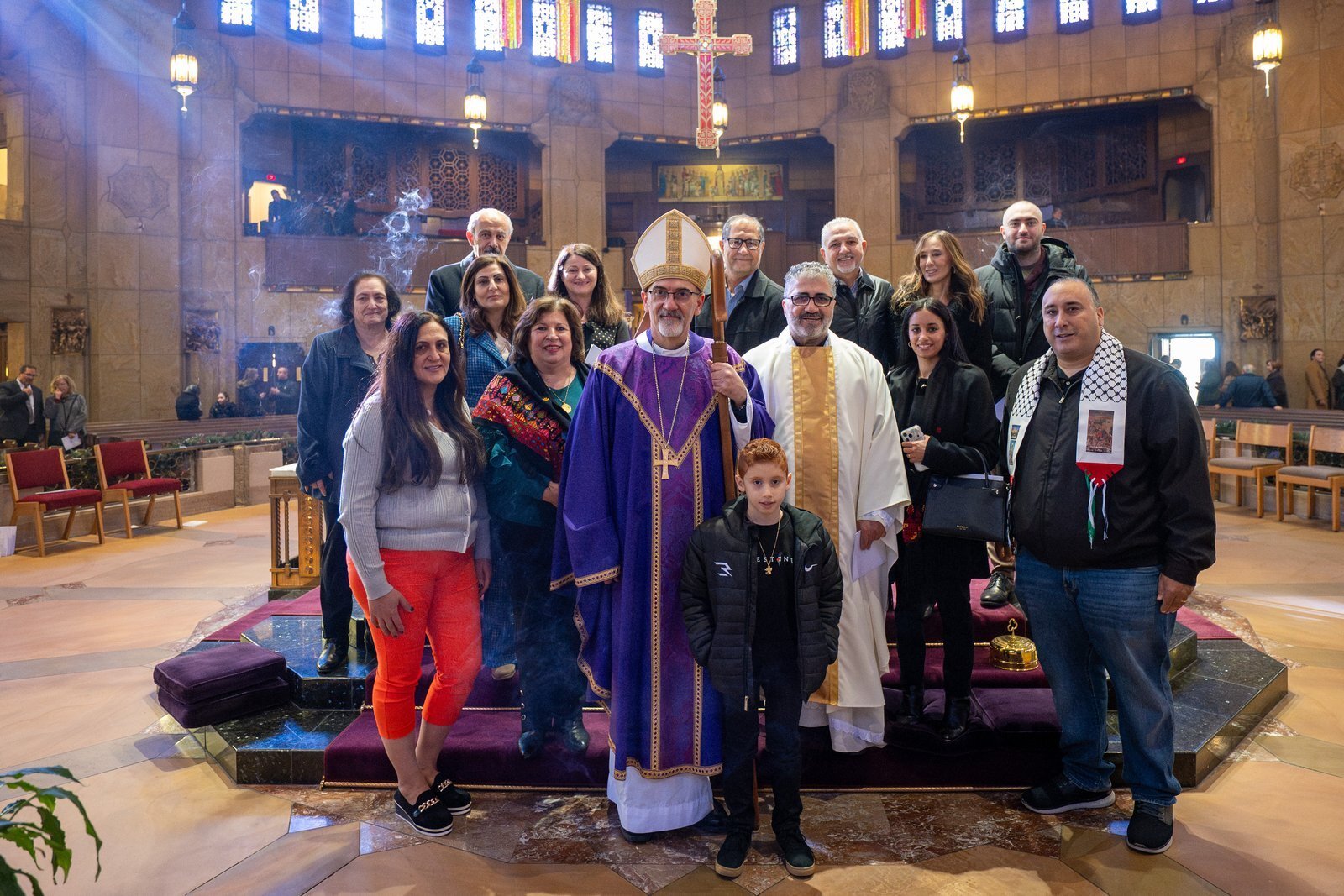 El cardenal Pizzaballa posa para una foto grupal con el P. Fares Hattar, sacerdote del Patriarcado Latino de Jerusalén que presta servicio en Ann Arbor, y con familias árabes católicas al finalizar la Misa. El P. Hattar expresó que fue una gran bendición poder celebrar la Eucaristía junto a su obispo.