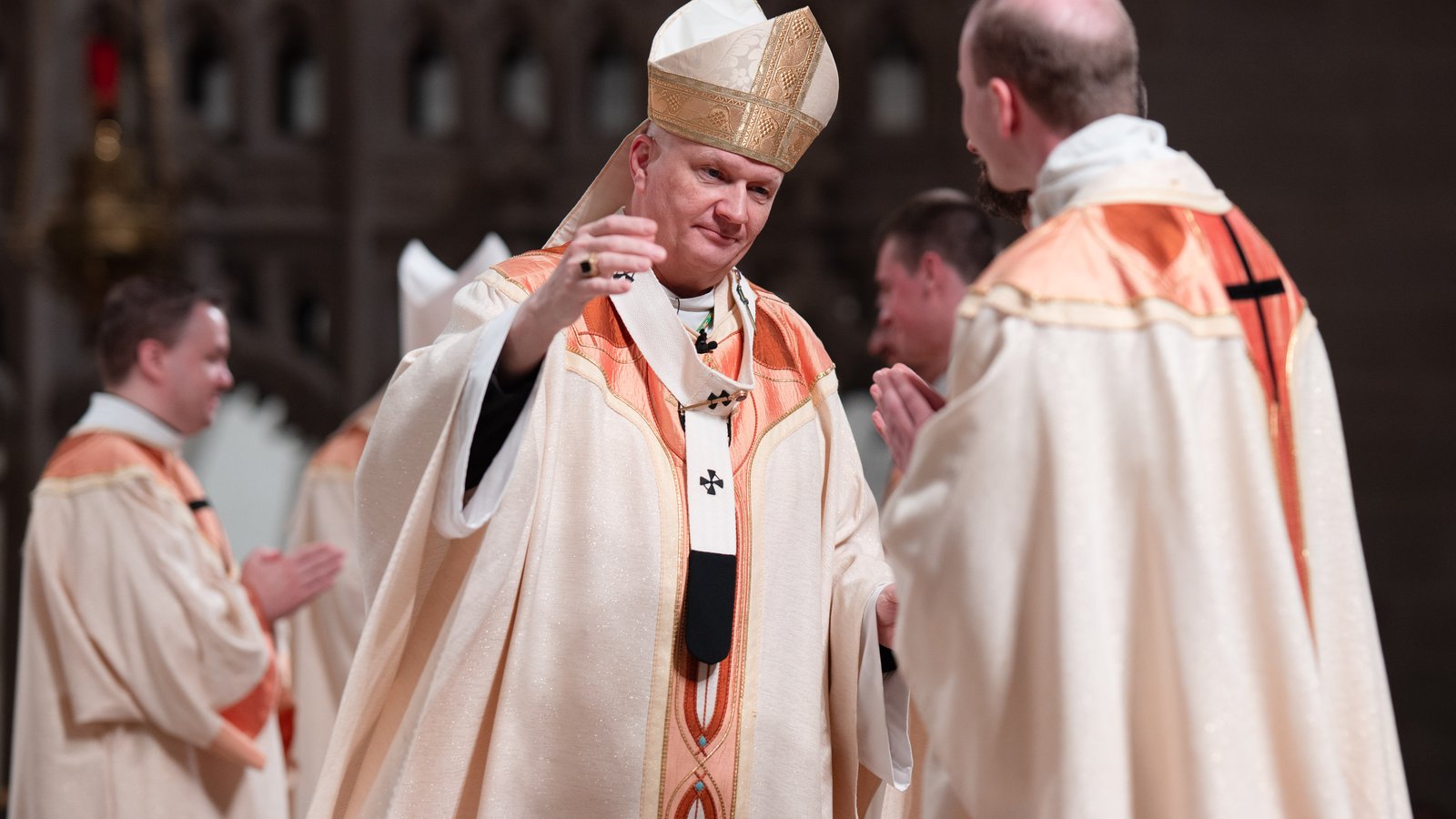 El arzobispo Weisenburger abraza al padre Daniel Whalen y a sus compañeros después de ordenarlos sacerdotes.