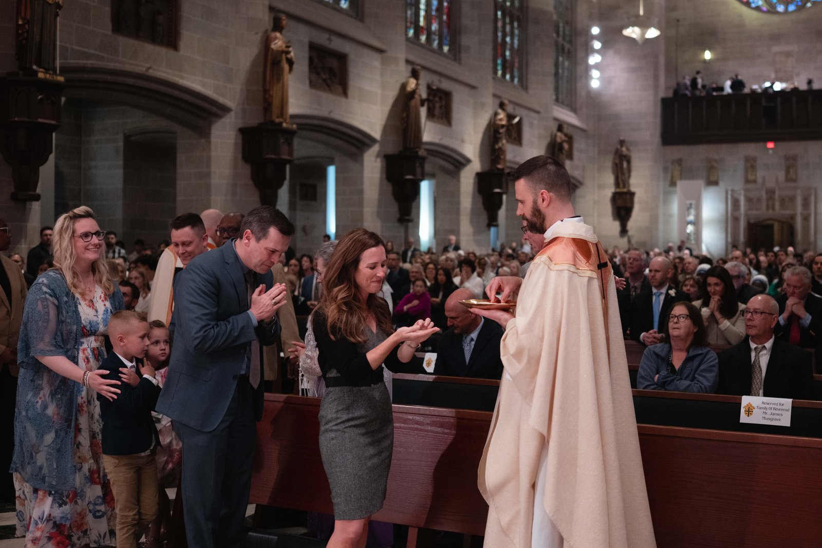Fr. James Musgrave offers Communion to the faithful of the Archdiocese of Detroit, starting with his family and friends, who gathered in the front of the cathedral to support him and his classmates.