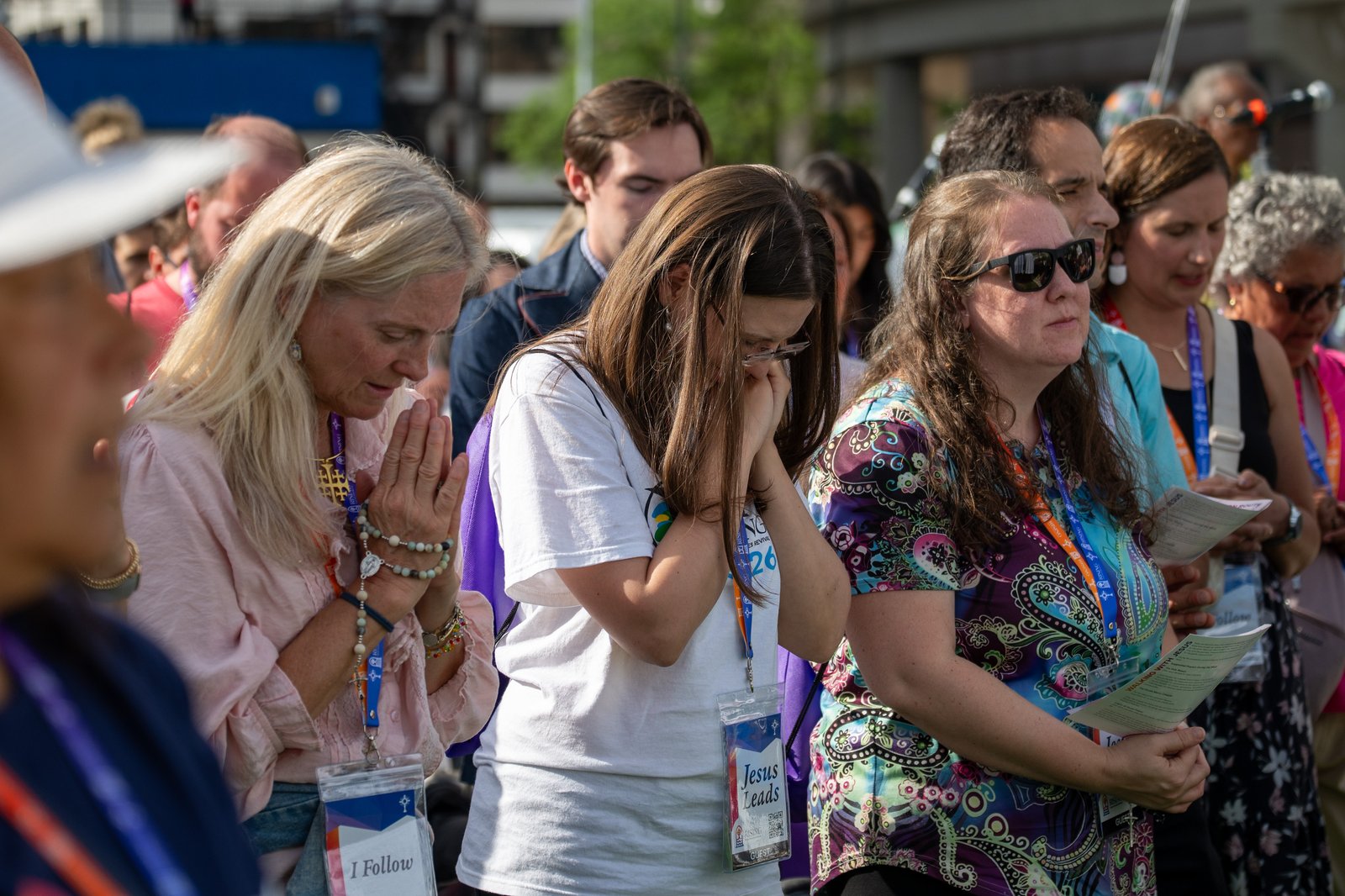 Women and men kneel in adoration as Jesus is lifted above the congregation outside Huntington Place. (Tim Fuller | Detroit Catholic)