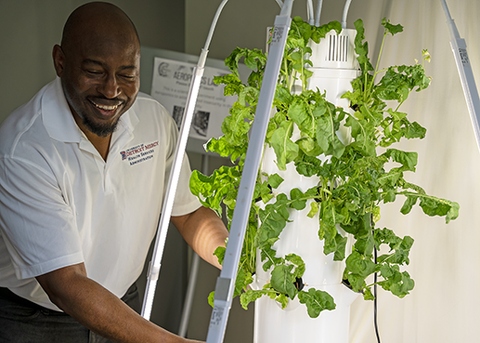 Olla tends to the plants in the center's aeroponics garden, which is one example of the use of emerging technologies that can utilize artificial intelligence applications to improve the lives of those in the local community, he said.