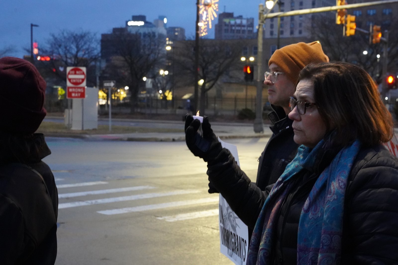 Participantes sostienen velas durante una vigilia de oración en silencio frente a la oficina del Servicio de Inmigración y Control de Aduanas (ICE) en Detroit, sobre Michigan Avenue.
