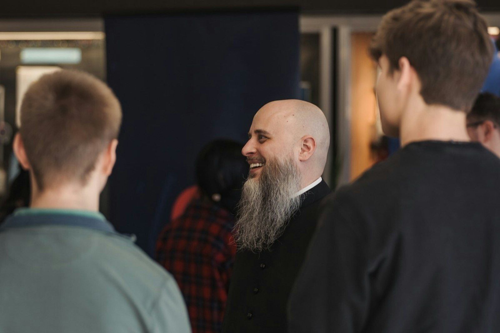 El P. Giera se ríe junto a los estudiantes en la conferencia anual de jóvenes RISE en febrero de 2024 en Mercy High School en Farmington. (Leah Butalid | Detroit Catholic)