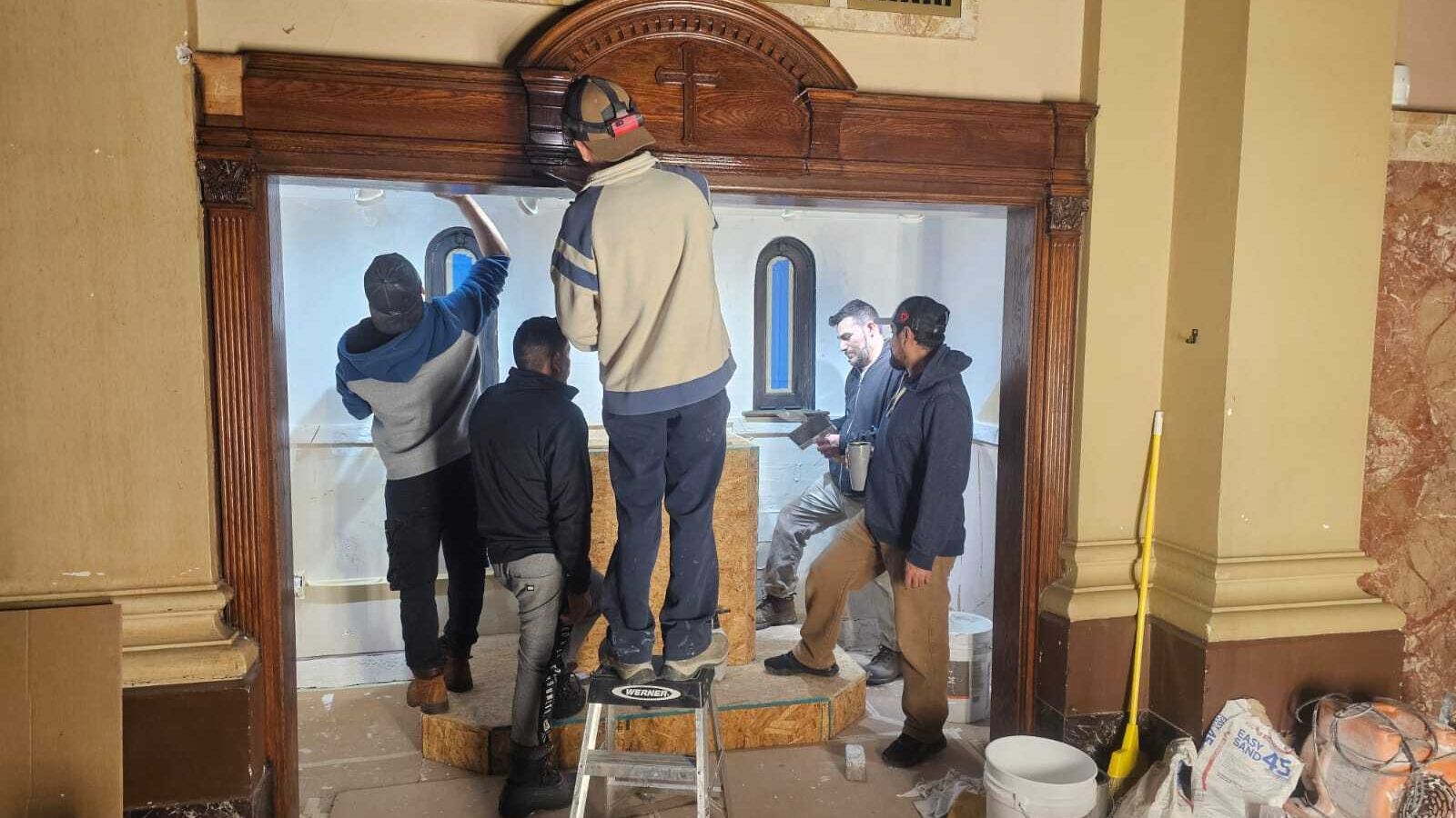 En uno de los confesionarios de la iglesia se construyó un nicho especial que alberga la reliquia de primer grado de San José Sánchez del Río.  Los hombres encargados de realizar el trabajo son del Ministerio de Emaus. (Fotos cortesía de Jaime Diaz-Herrera)