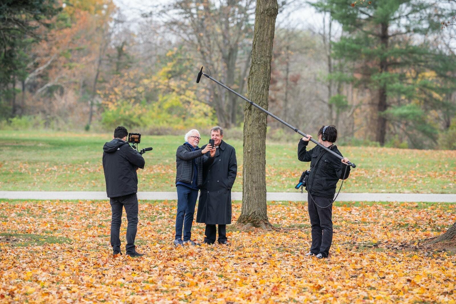 Filmmaker Keith Famie talks with Detroit Archbishop Allen H. Vigneron on the grounds of Holy Sepulchre Cemetery following the All Souls Day Mass on Nov. 2. Famie and his team filmed the Mass for his new project, "Detroit: The City of Faith." (Valaurian Waller | Detroit Catholic)