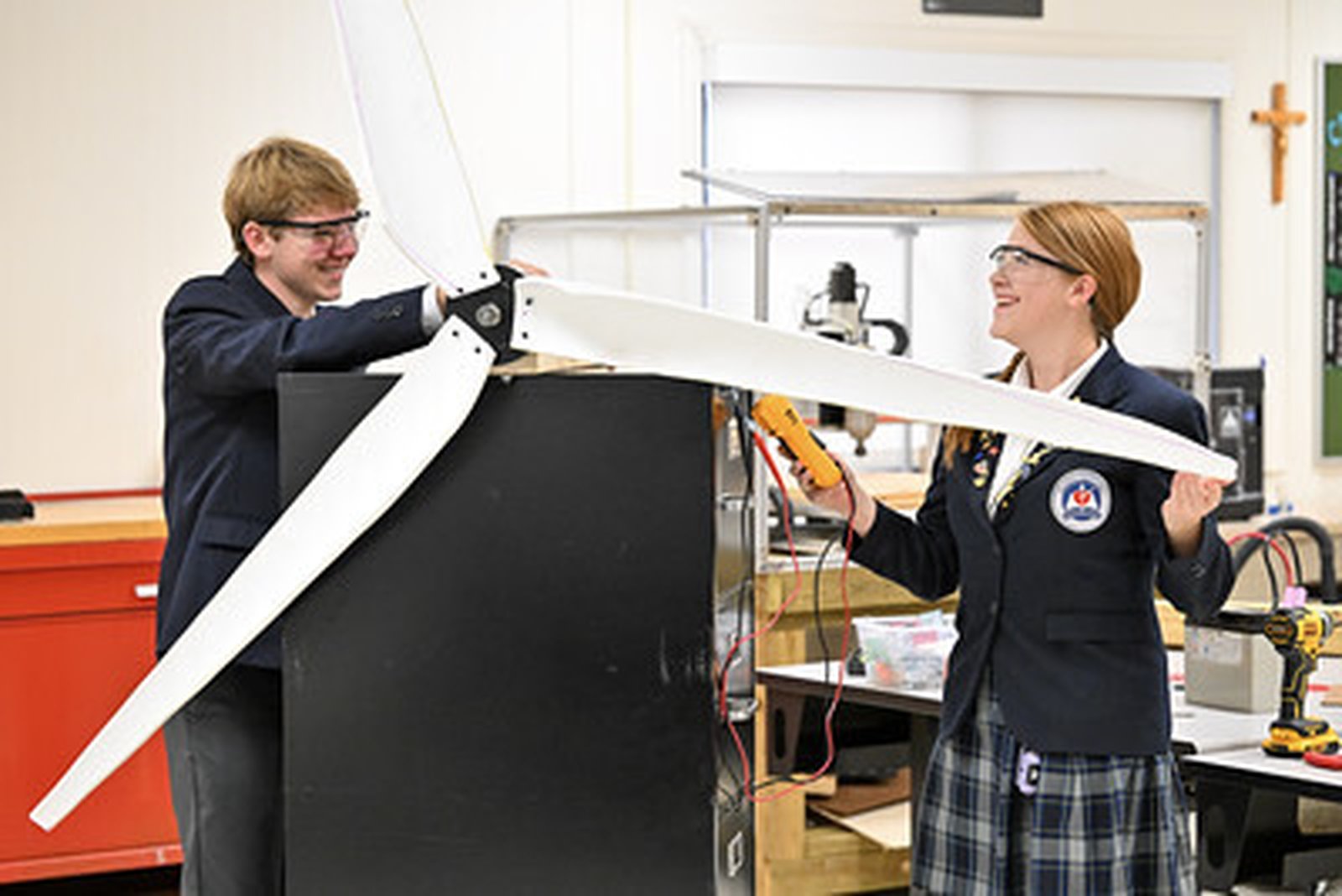 Los estudiantes de último año Sam W. y Kassandra W. trabajan en su turbina eólica en la clase STEAM Capstone.
