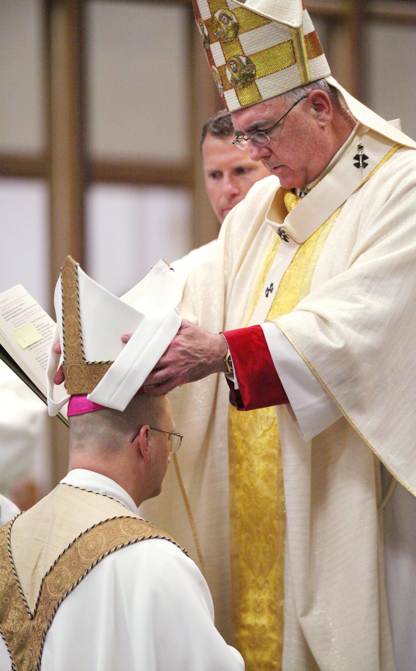 Archbishop Joseph F. Naumann of Kansas City places the miter atop then-Bishop Weisenburger’s head during the latter’s episcopal consecration and installation as the 11th bishop of Salina, Kansas, on May 1, 2012, at the Cathedral of the Sacred Heart in Salina.