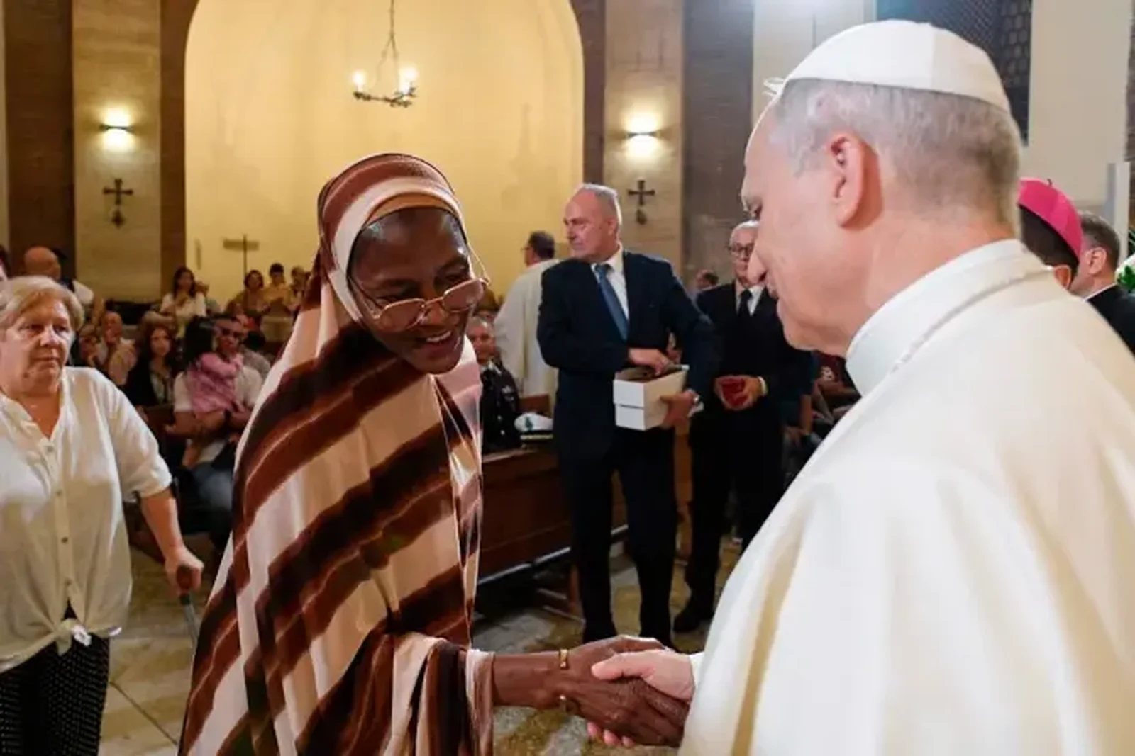 El Papa León XIV saluda a una refugiada que es atendida por la diócesis italiana de Albano. | Crédito: Vatican Media.