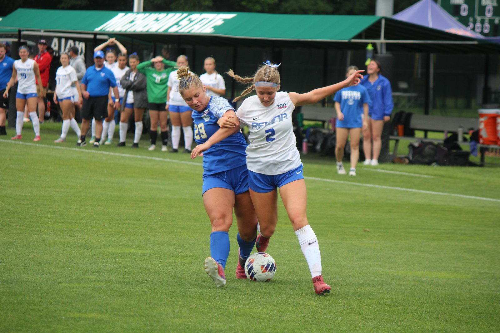 Catholic Central defender Riane Andrzejewski tries to slow the progress of Regina’s Jenna Moeller.