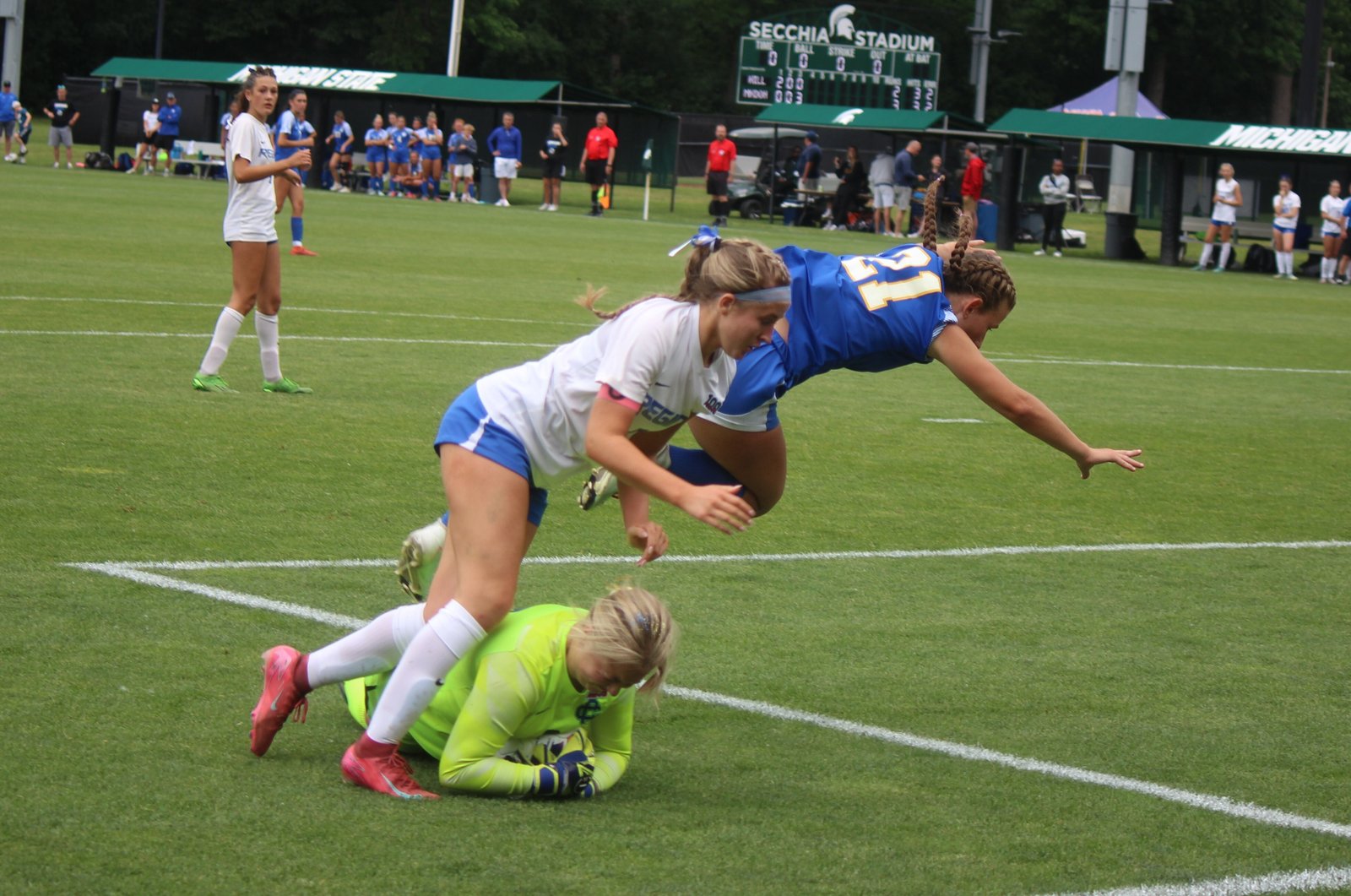 Grand Rapids Catholic Central goalkeeper Charlie Walker gets to the ball an instant before Regina’s Jenna Moeller and Cougar defender Alyssa Yost come crashing in. Moeller had four shots on goal, the most of any player in the contest.