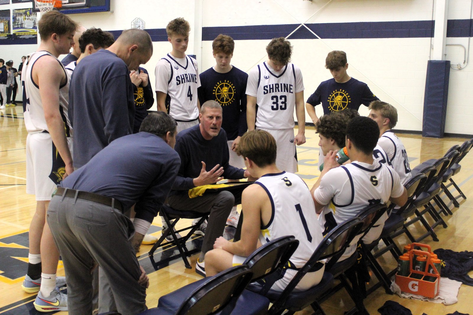 Shrine coach Michael Maryanski emphasizes a point with his team during a second-half timeout. The Knights outscored visiting Ann Arbor Greenhills 29-10 over the final two quarters to earn the victory in the Catholic League quarterfinal game.