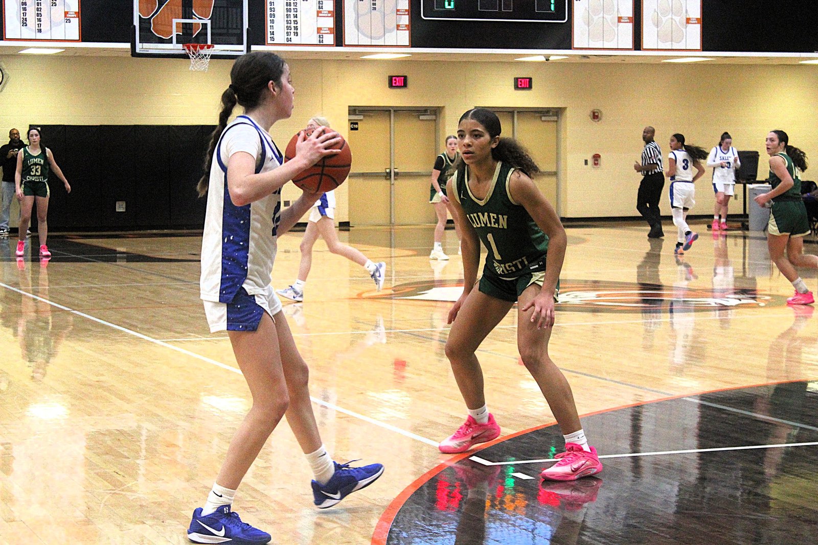 Lumen Christi sophomore Kenna Hunt keeps her eye on the ball while guarding Plymouth Salem’s Lainey Claramunt. Hunt forced several steals leading to transition baskets, and topped all scorers with 21 points in the Titans’ 68-37 victory Dec. 13.