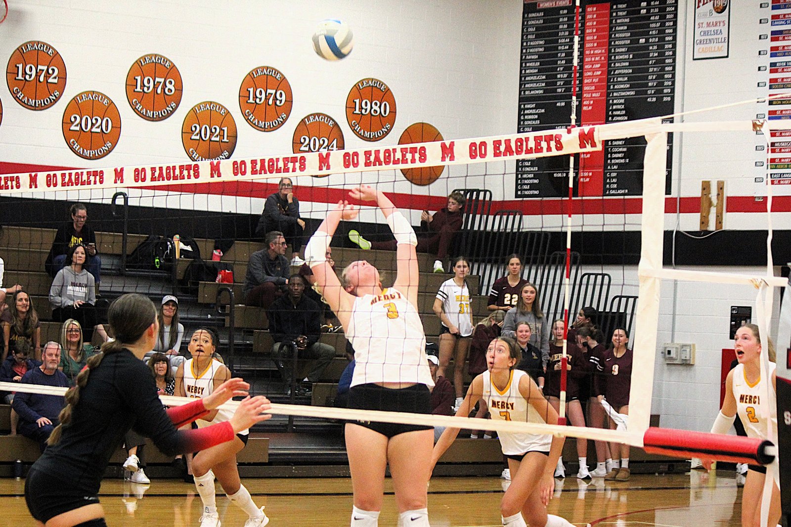 Sophomore Kaelyn Easton sets the ball toward junior outside hitter Cydnee Drake (10). Easton had 36 assists in Mercy’s four-set victory over the Eaglets on their home court.